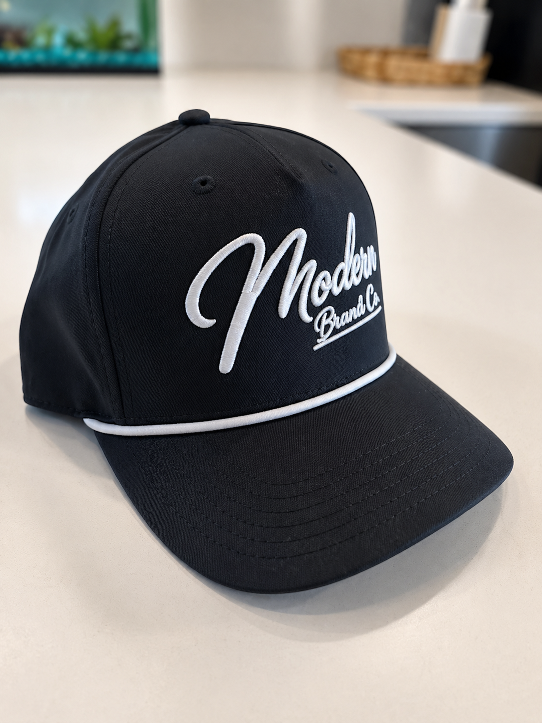 Black baseball cap with white embroidered text reading 'Modern Brands Co.'.
