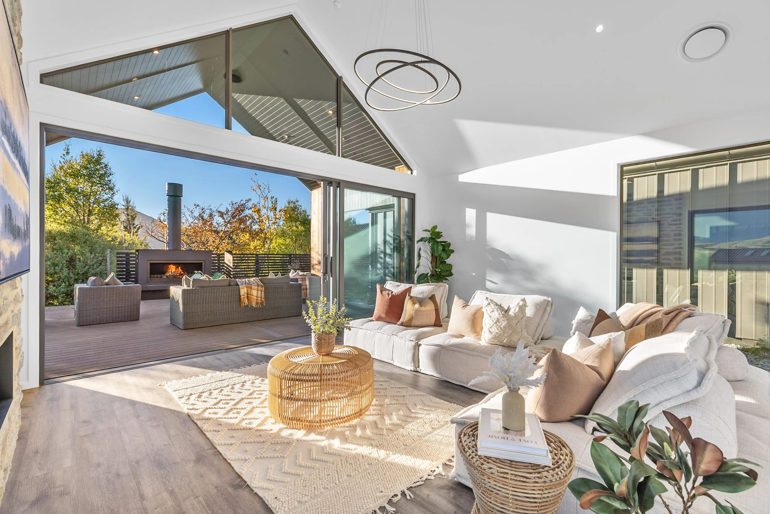 New build living room with glass ceiling, white sofa, and sliding doors to outdoor patio — Jacks Point, Queenstown
