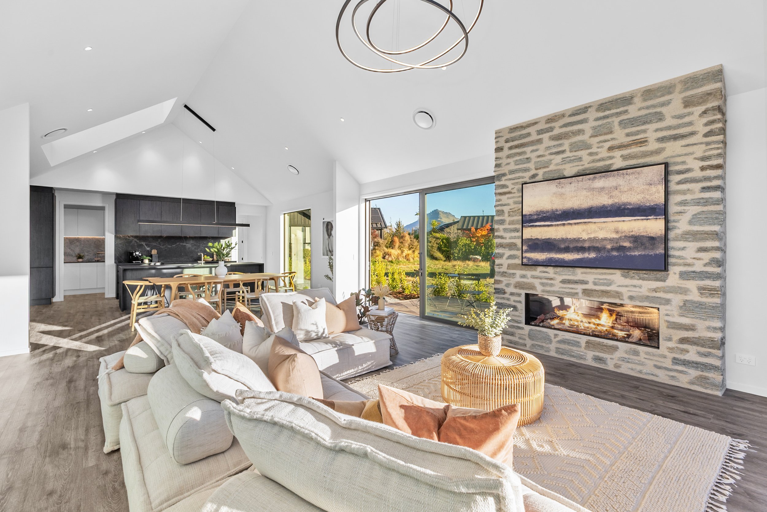 New build open-concept living room and kitchen with large windows and contemporary furnishings — Jacks Point, Queenstown