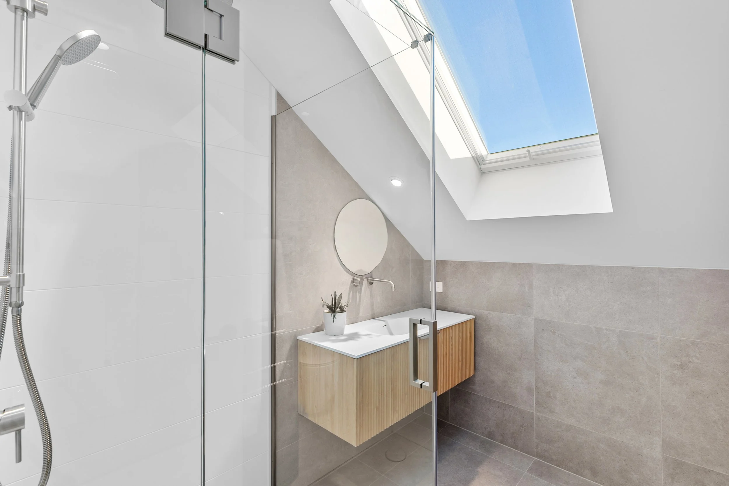 New build bathroom with skylight, wooden vanity, and glass-panelled walk-in shower — Jacks Point, Queenstown