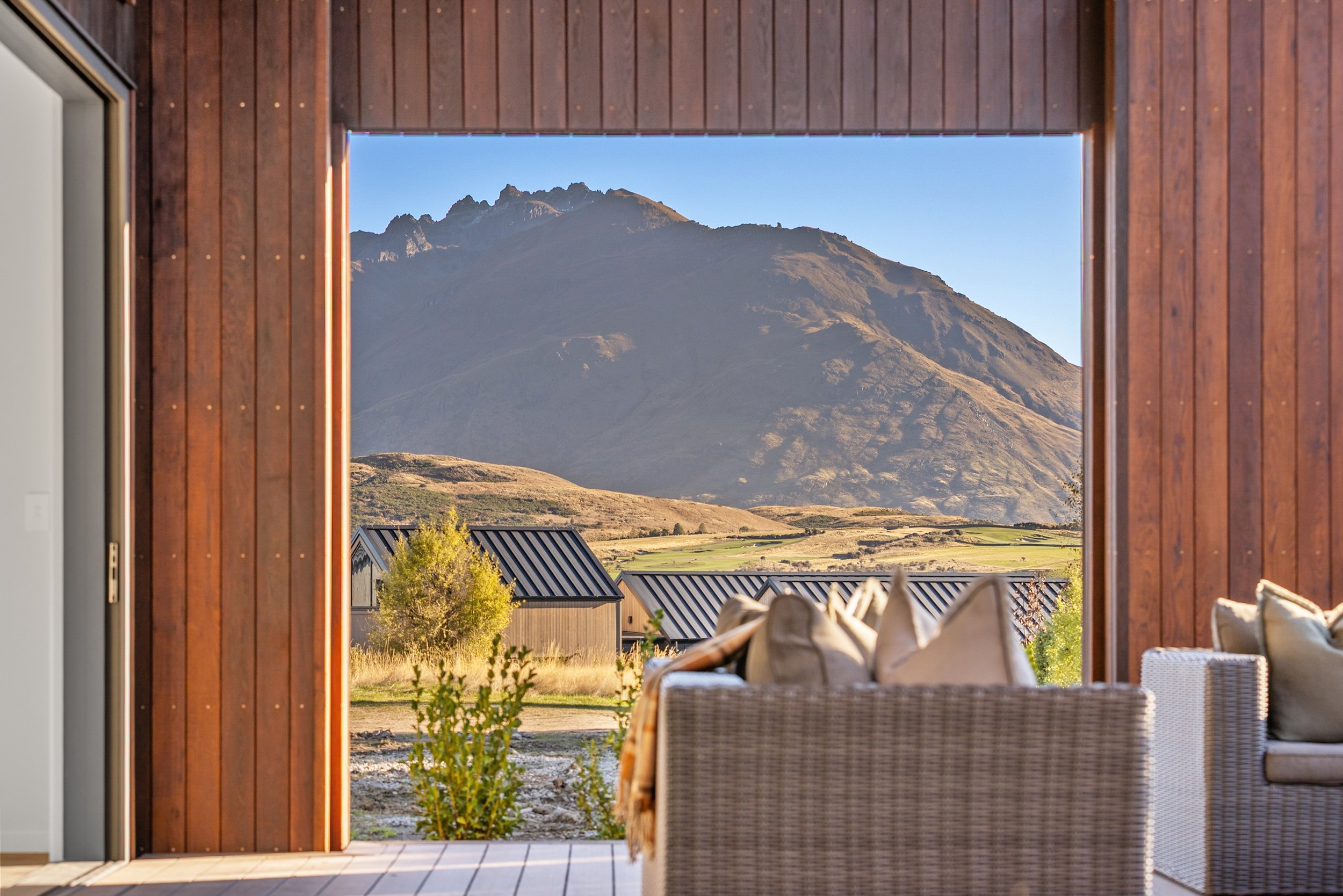 Mountain view from screened-in porch, wicker seating — Jacks Point, Queenstown