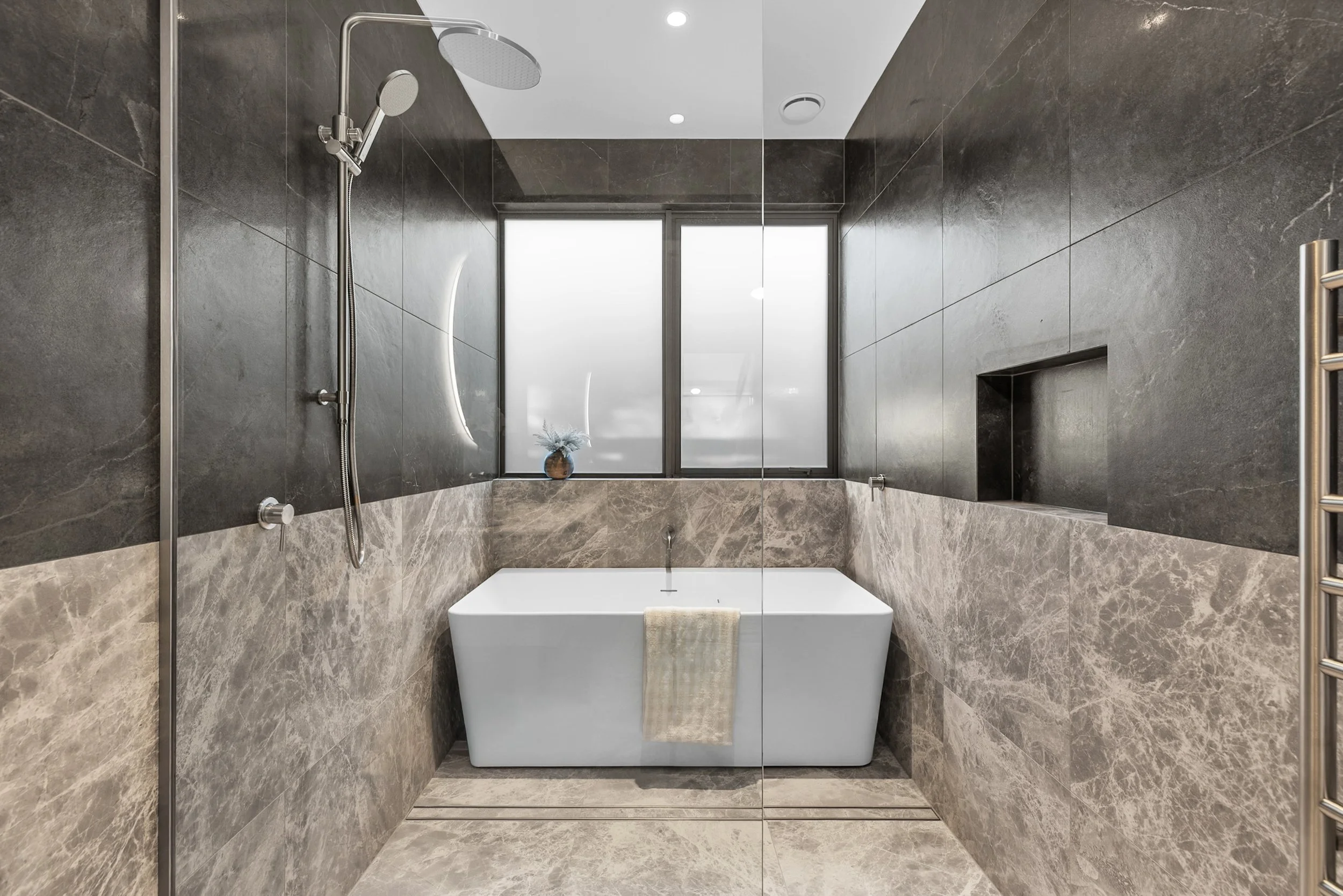 New build bathroom with dark grey tile shower, white bathtub, and large window — Jacks Point, Queenstown