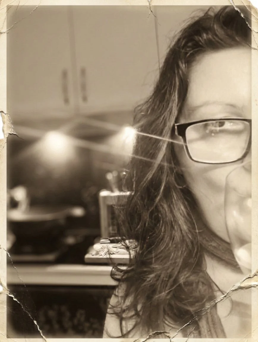 Artist Shanti Padme enjoying a glass of wine whilst cooking a meal.