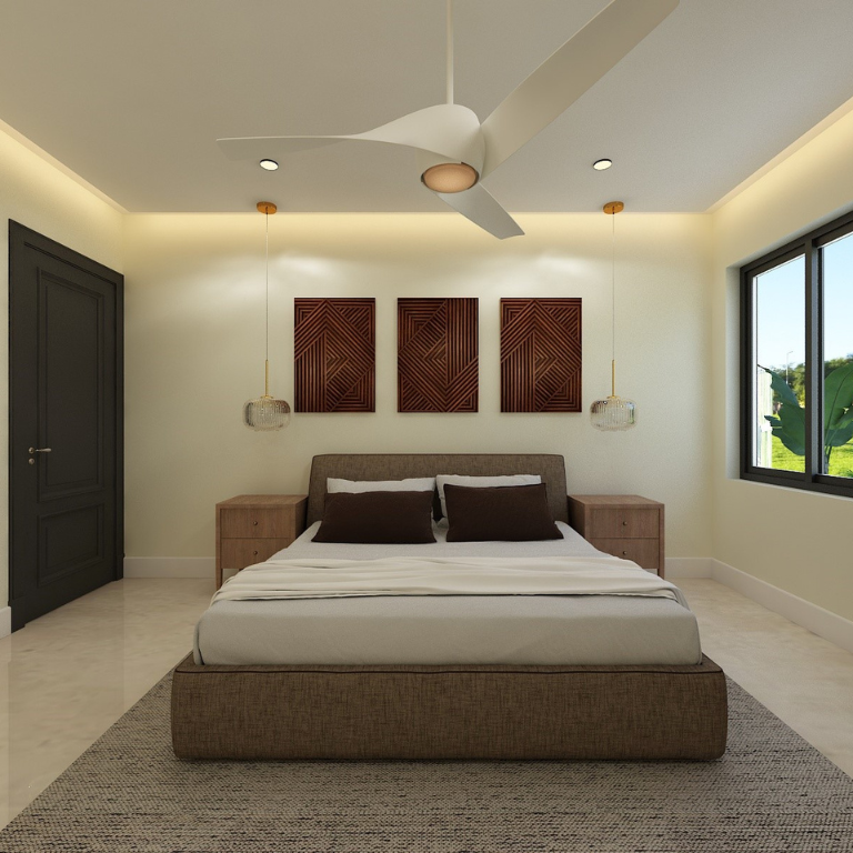 Modern bedroom with beige bed, dark pillows, wood nightstands, wall art, ceiling fan, and window with greenery outside.