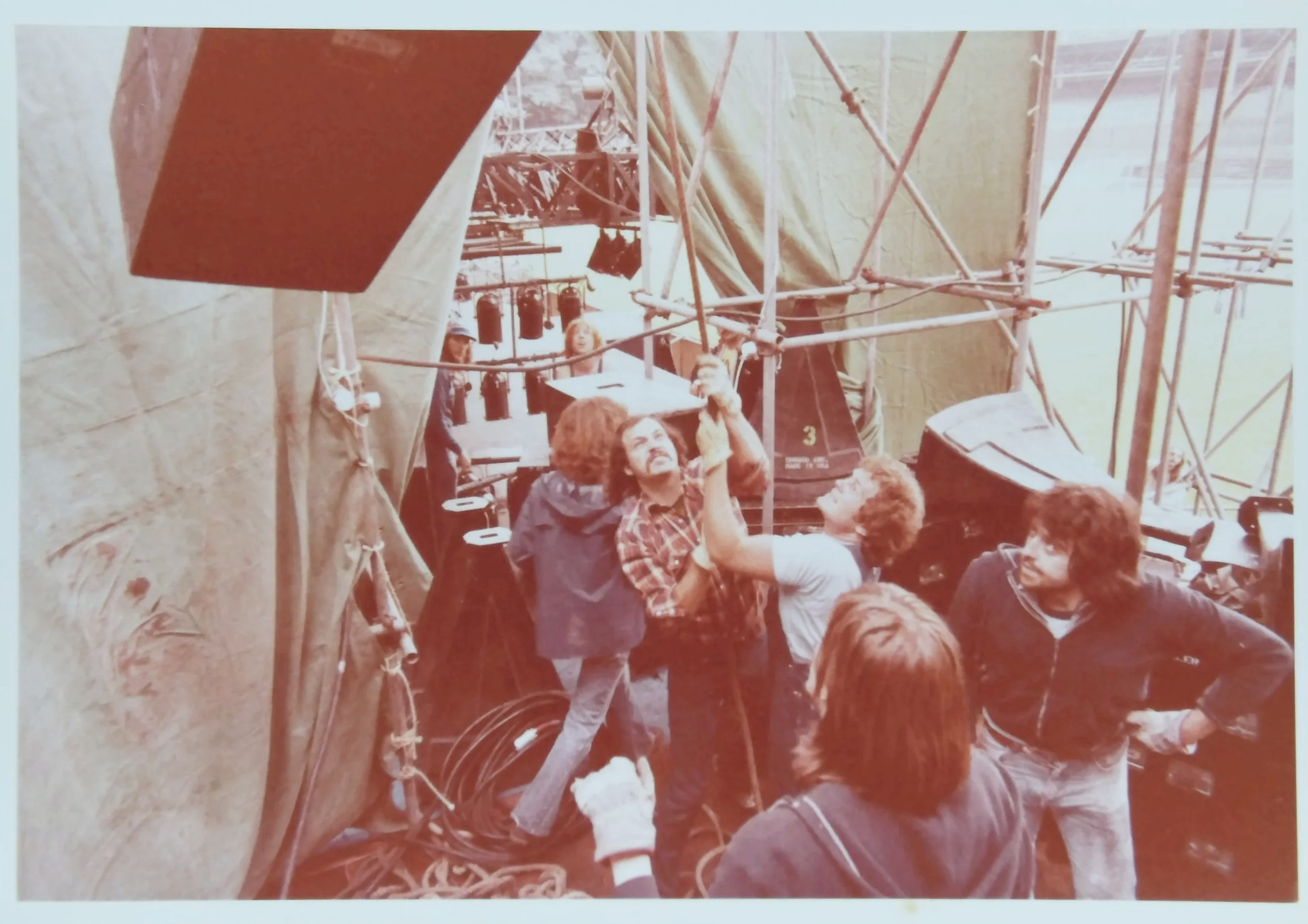 Genesis stage build, Open Air Festival, Germany, 1978. Showco alumni Craig Schertz, Johnny “JW” Roberts, and fellow crew members prepare the production before the audience arrives. Courtesy of the Showco Archives.