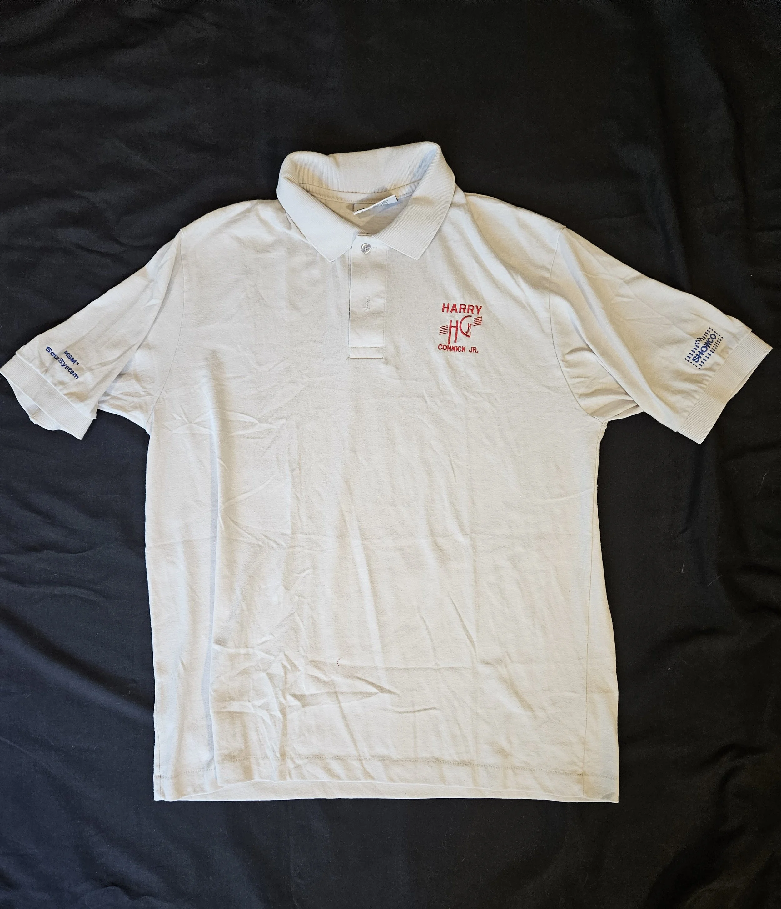 White Harry Connick Jr. polo shirt with embroidered chest and sleeve logos.
