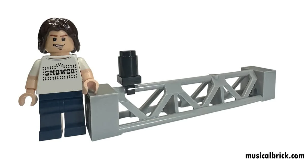 Lego minifigure with Showco shirt standing next to a model of a tower crane