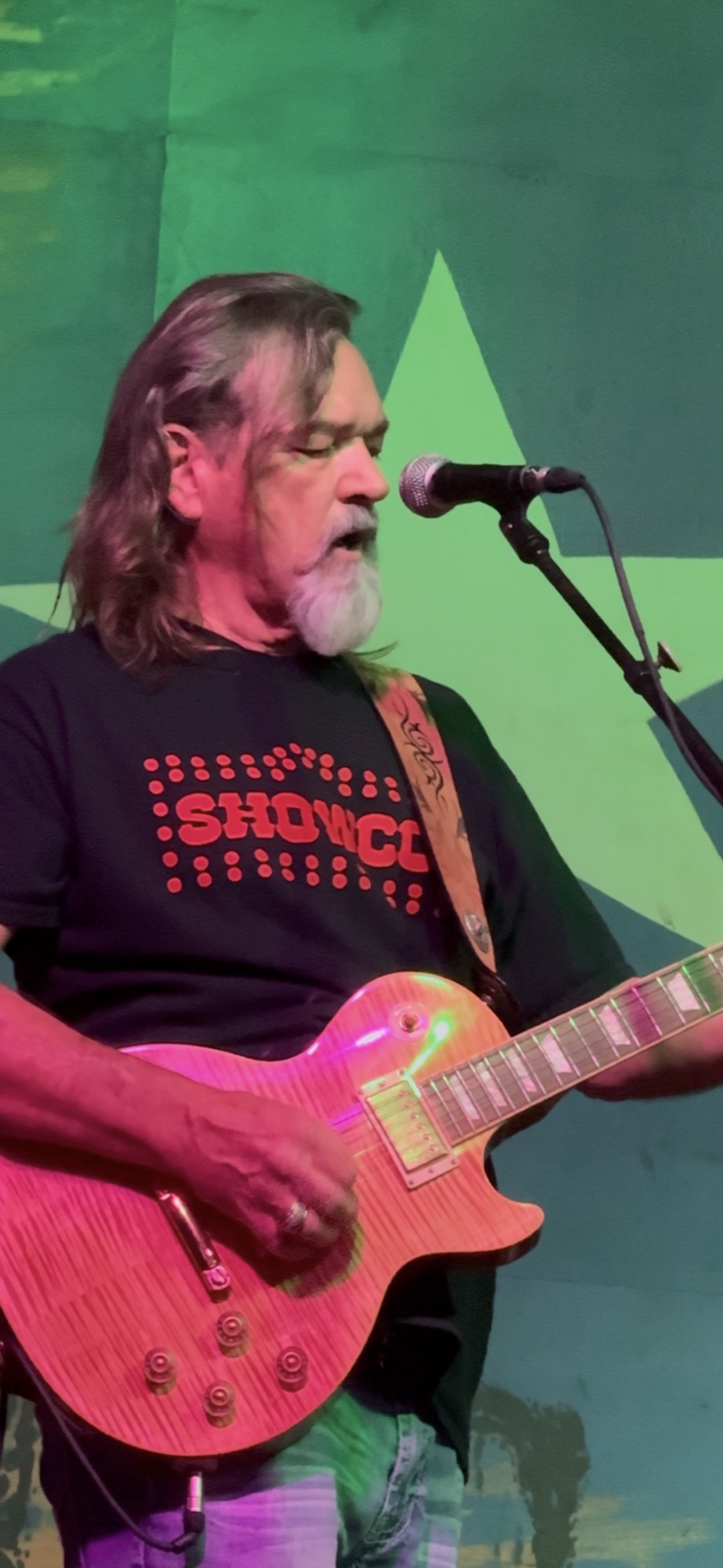 Matt Sullivan performing at a gig in a black and red Showco shirt
