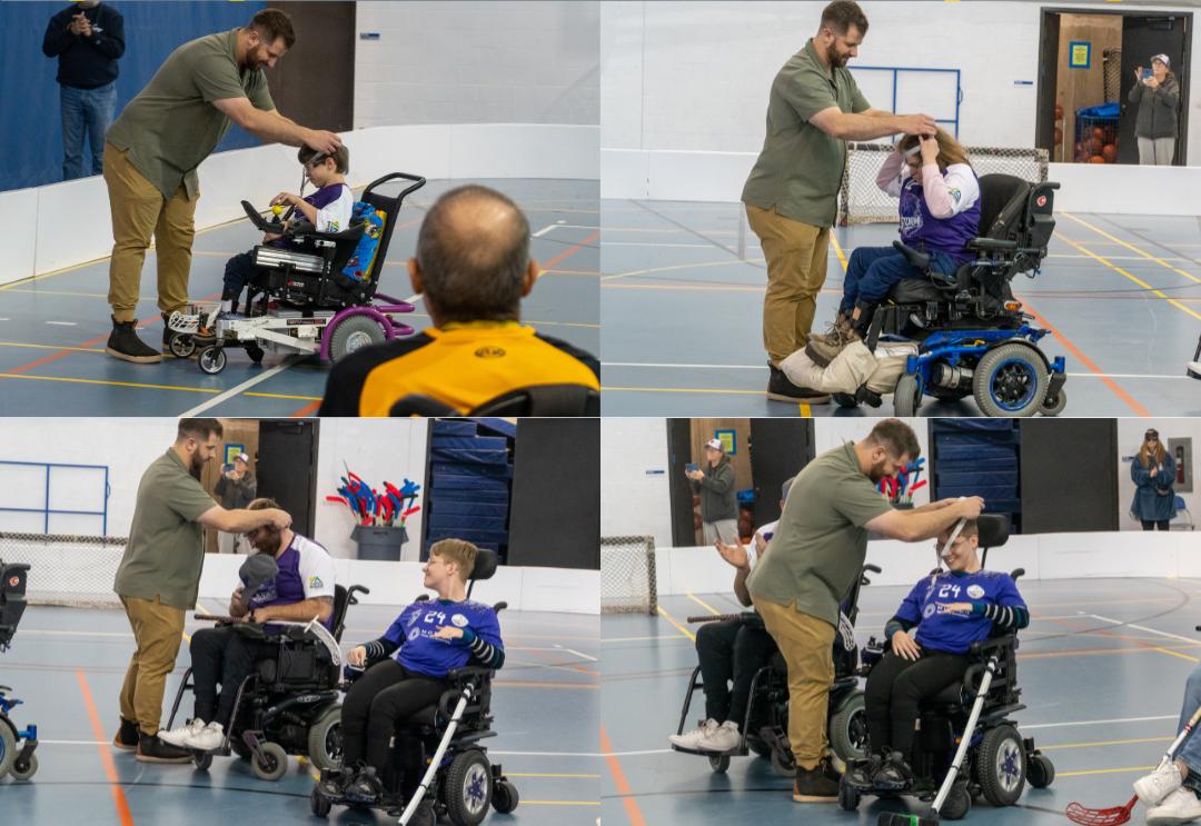 Man awarding medals to young athletes in a wheelchairs during a ceremony in a gymnasium.