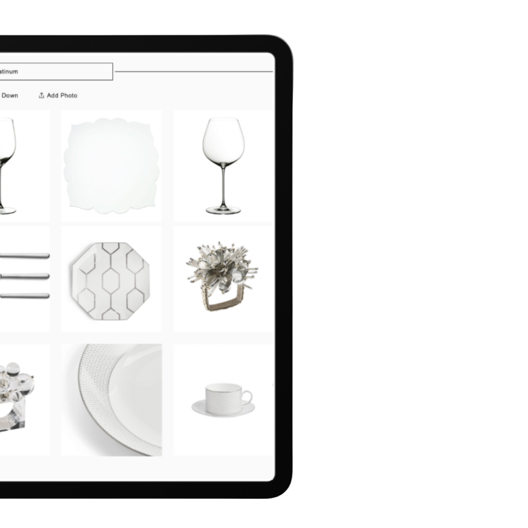 A tablet screen displaying various white and silver tableware and glassware, including wine glasses, plates, and decorative items.