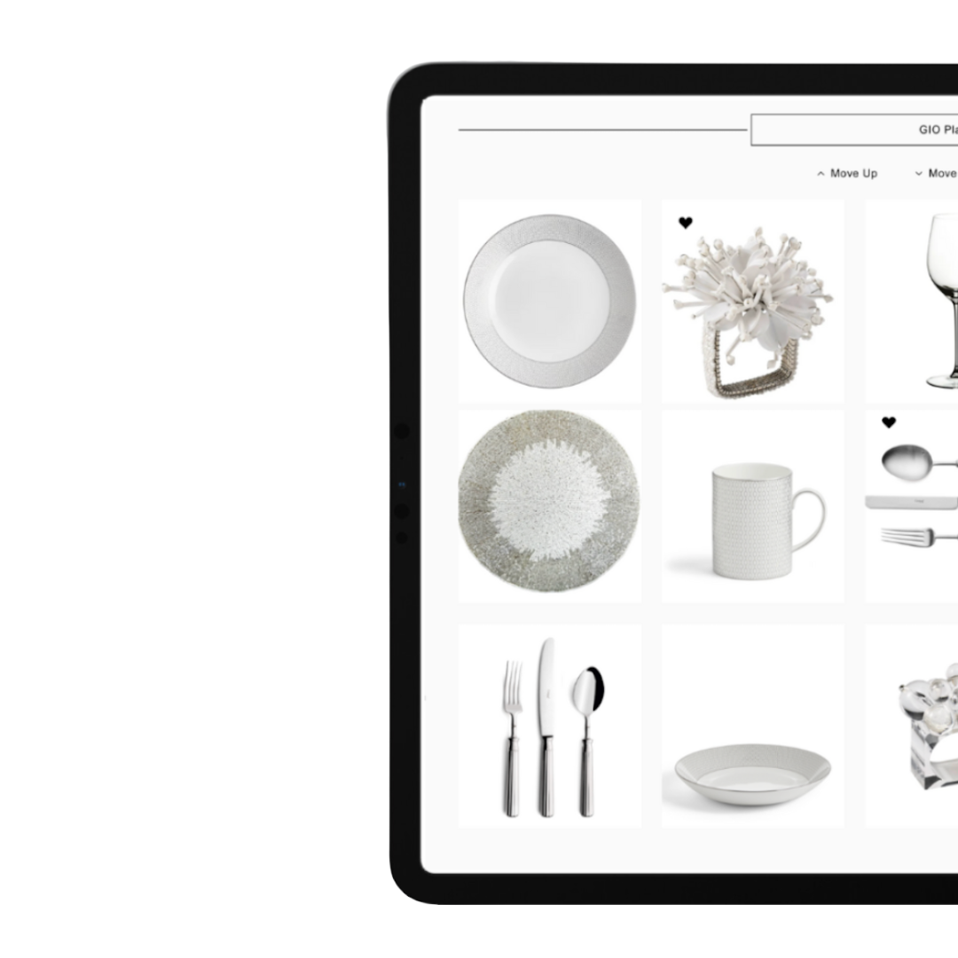 Digital tablet displaying a selection of white dinnerware and kitchen accessories, including plates, a flower arrangement, a mug, cutlery, a bowl, and decorative items.