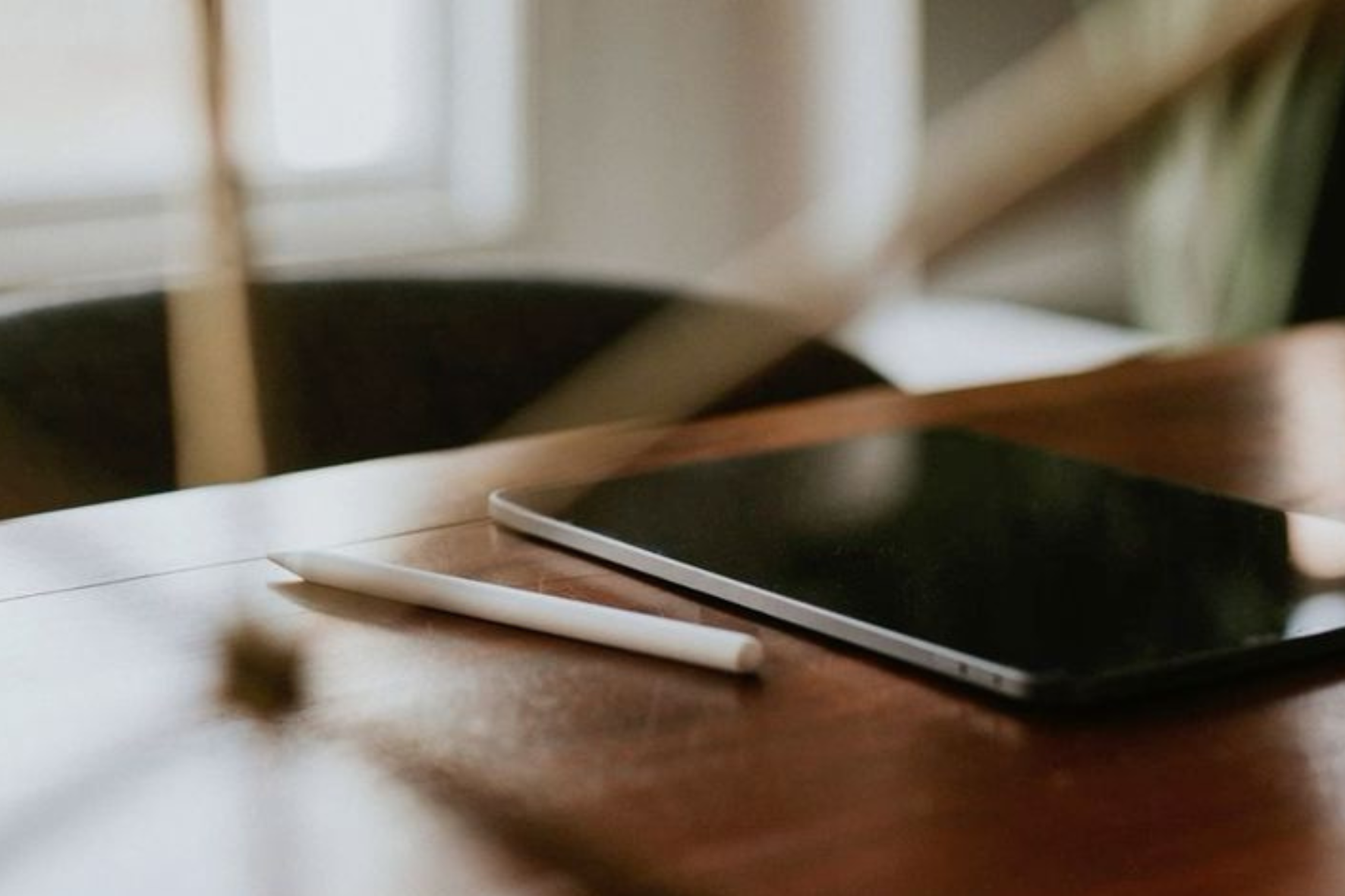 A tablet with a stylus on a wooden table