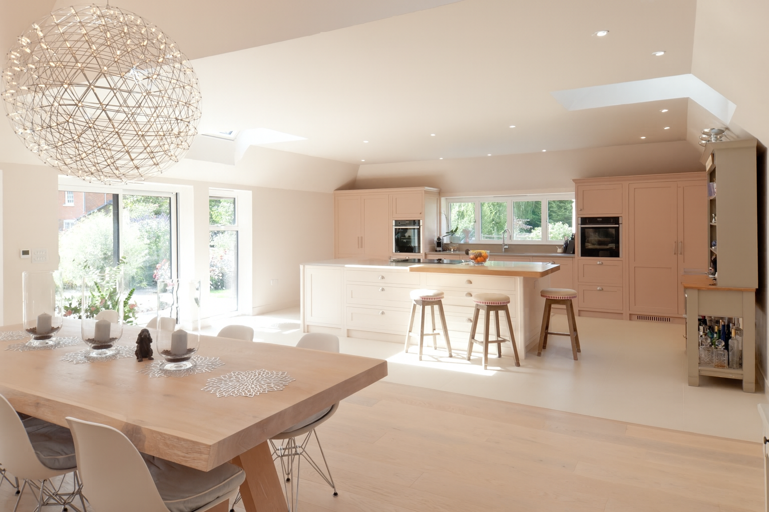 Light-filled bespoke kitchen with painted cabinetry, large central island and natural oak flooring.