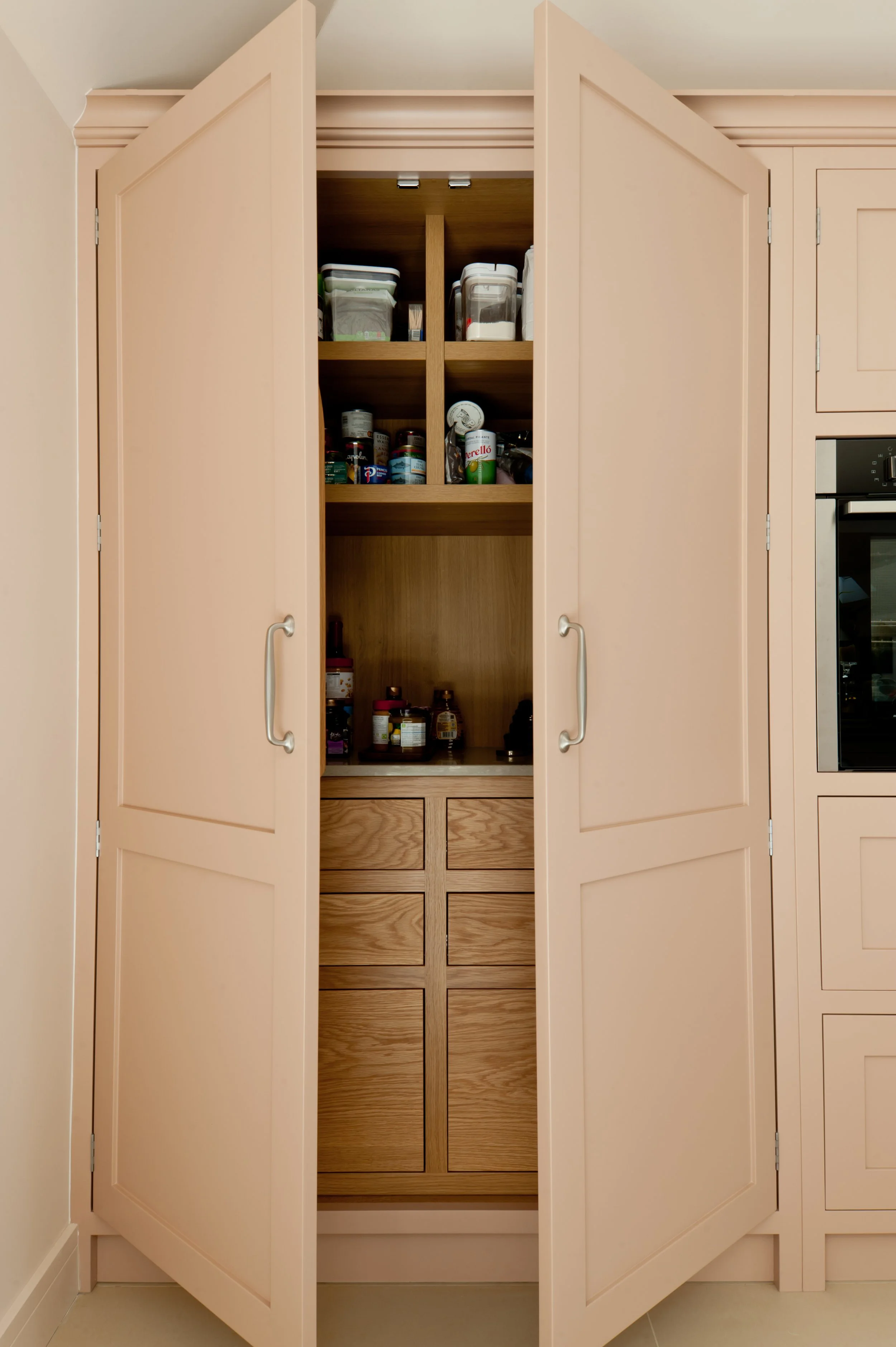 Bespoke kitchen pantry with painted doors, oak internal drawers and fitted storage.