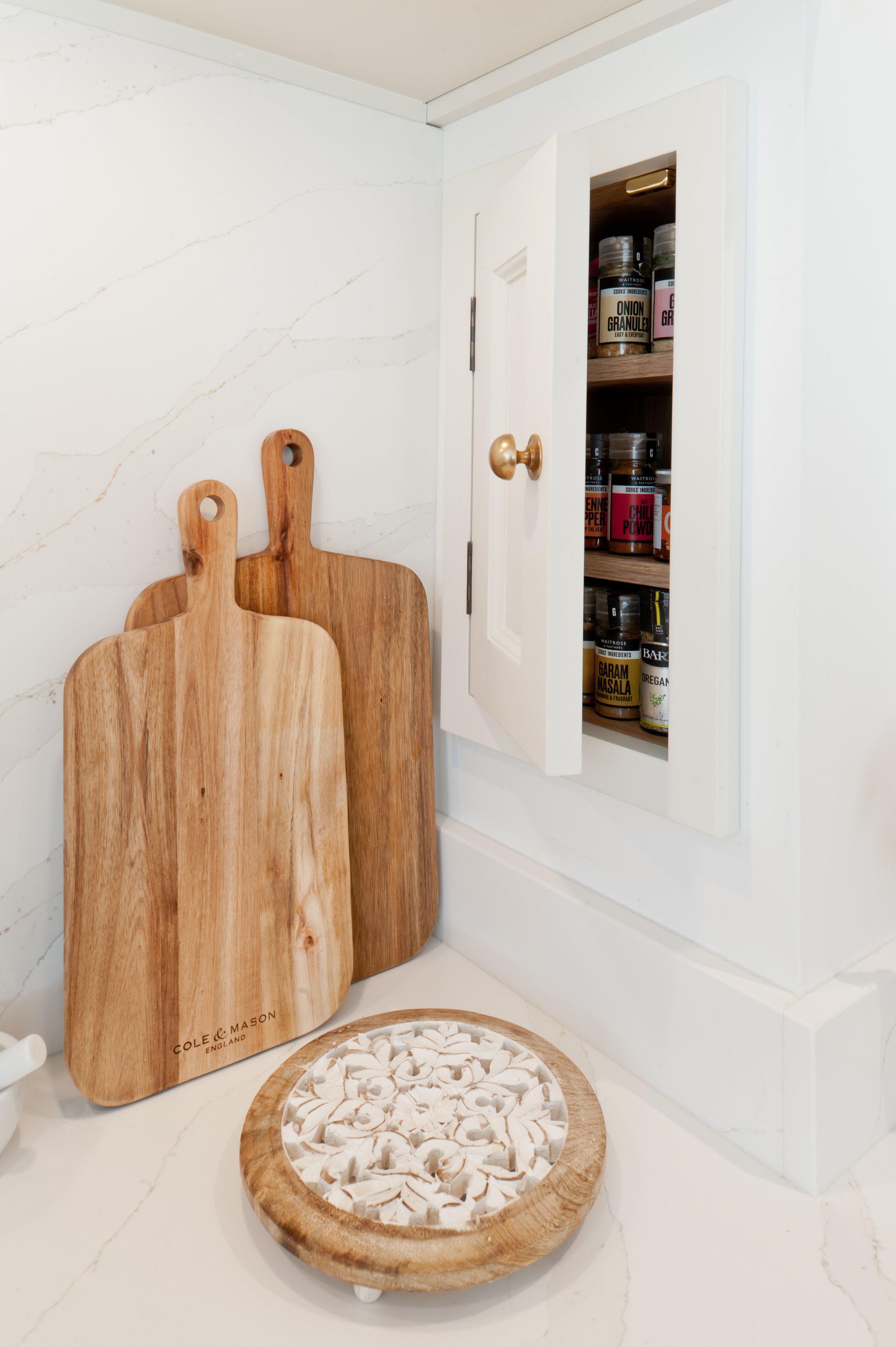 Bespoke spice cupboards and brass tap detail around Lacanche range in handcrafted kitchen by Collins Bespoke Kent.