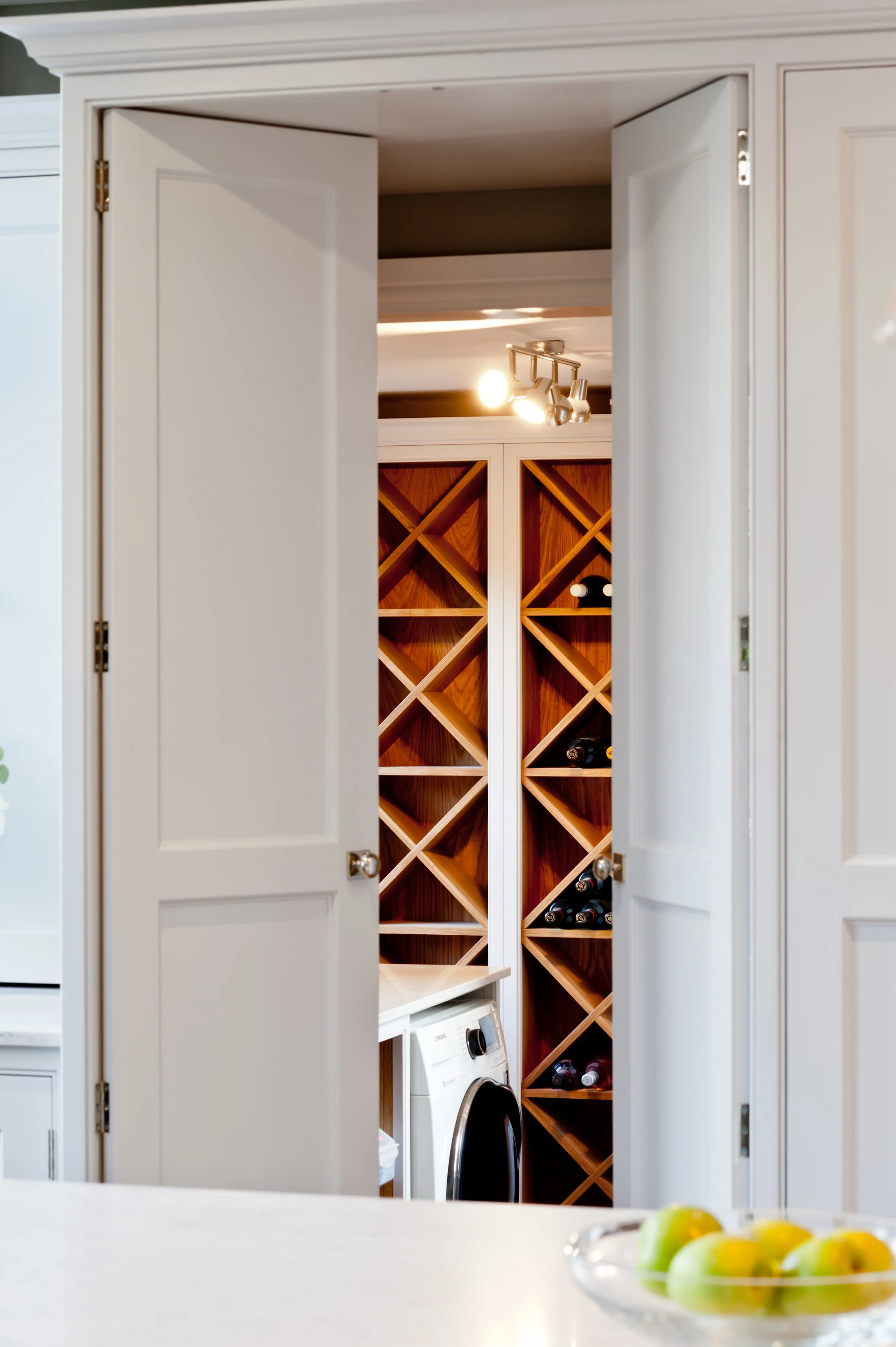 A well-kept secret. Bespoke concealed wine storage hidden seamlessly behind handcrafted cabinetry.