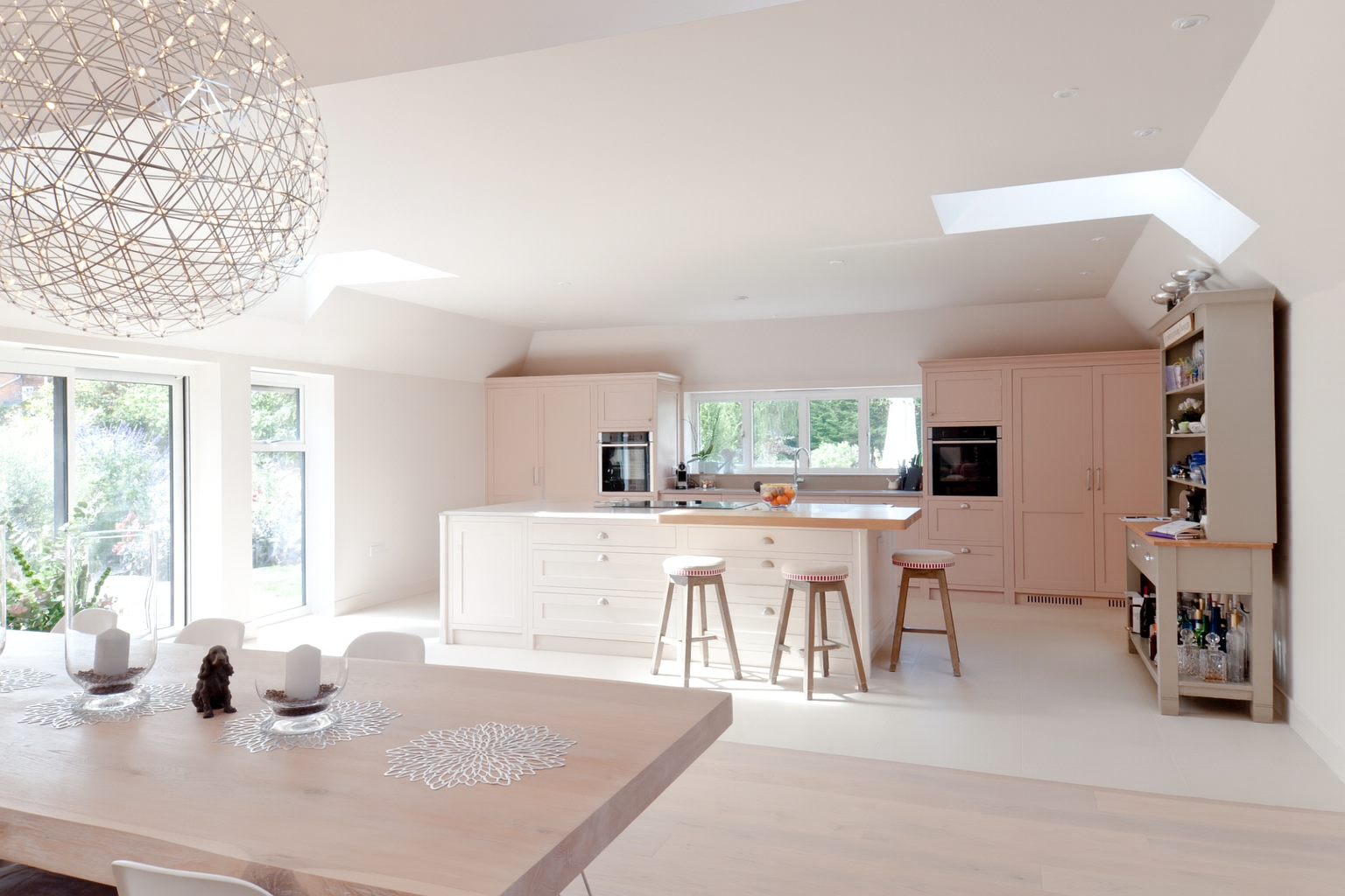 Bright bespoke kitchen overlooking the garden, with handcrafted cabinetry and a large central island.