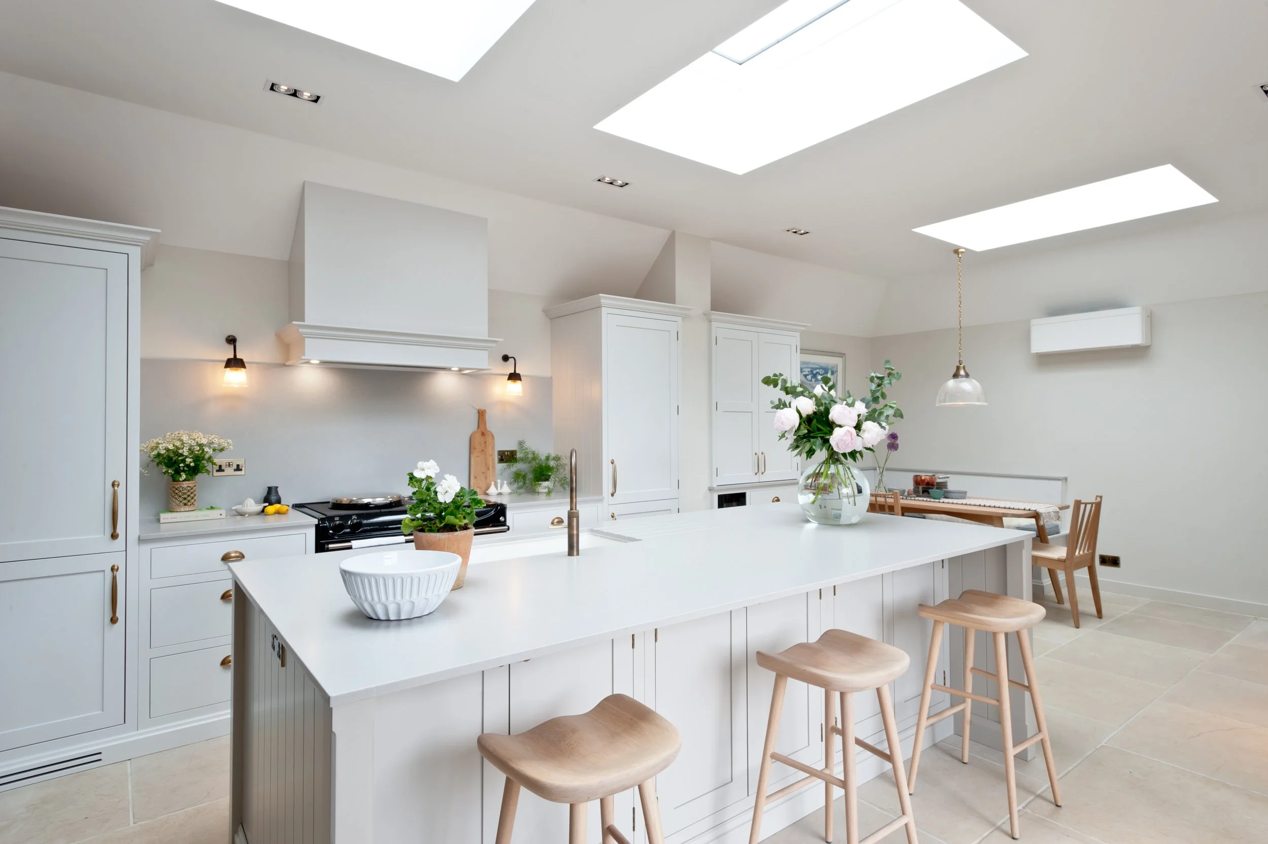 Bespoke kitchen island with quartz worktop, handcrafted cabinetry and informal timber bar stool seating.