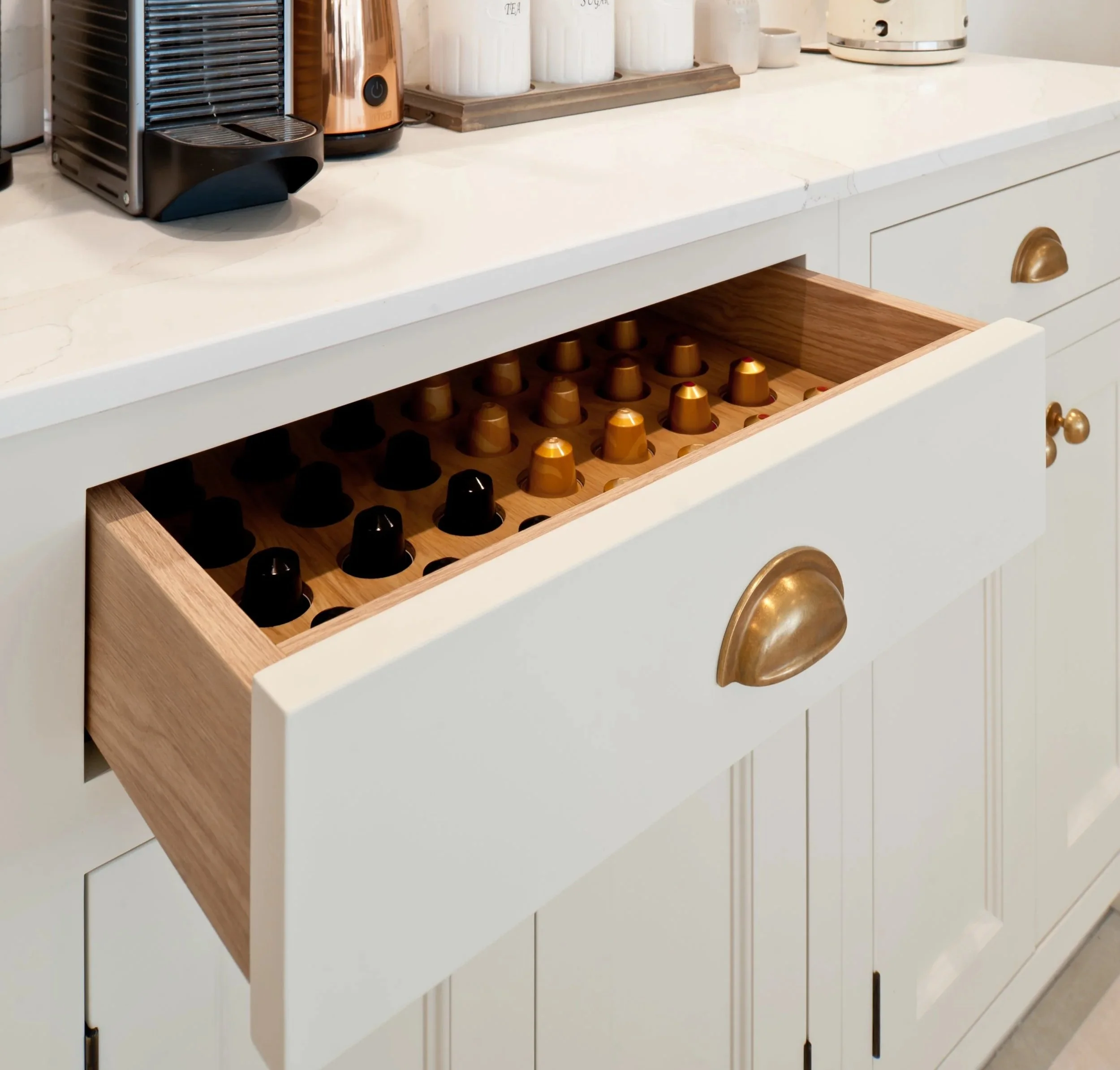 Close-up of bespoke coffee station with brass handles, quartz surface and integrated storage drawers in a Collins Bespoke kitchen.