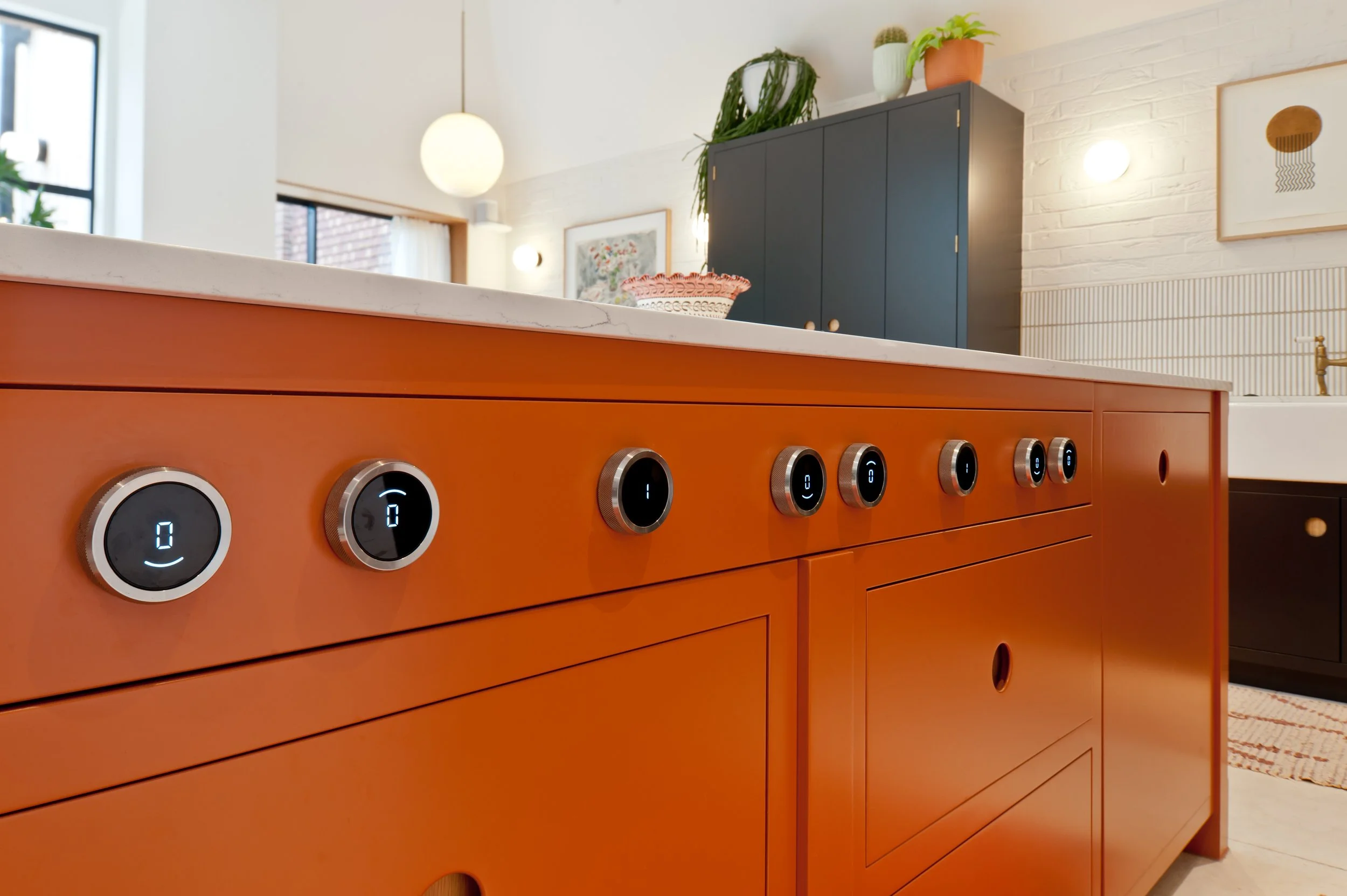 bespoke contemporary kitchen with recessed circular handles finished in orange and black