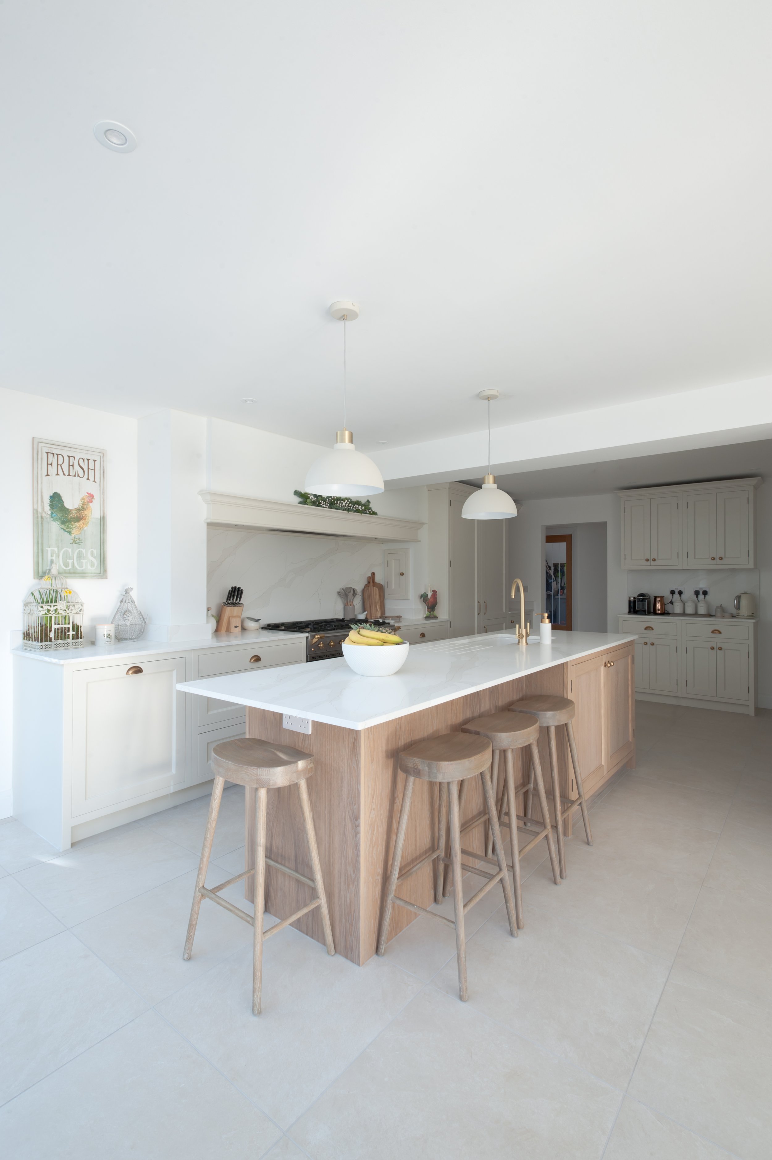 Open-plan kitchen and dining area featuring bespoke cabinetry, oak island and minimalist neutral design in Canterbury.
