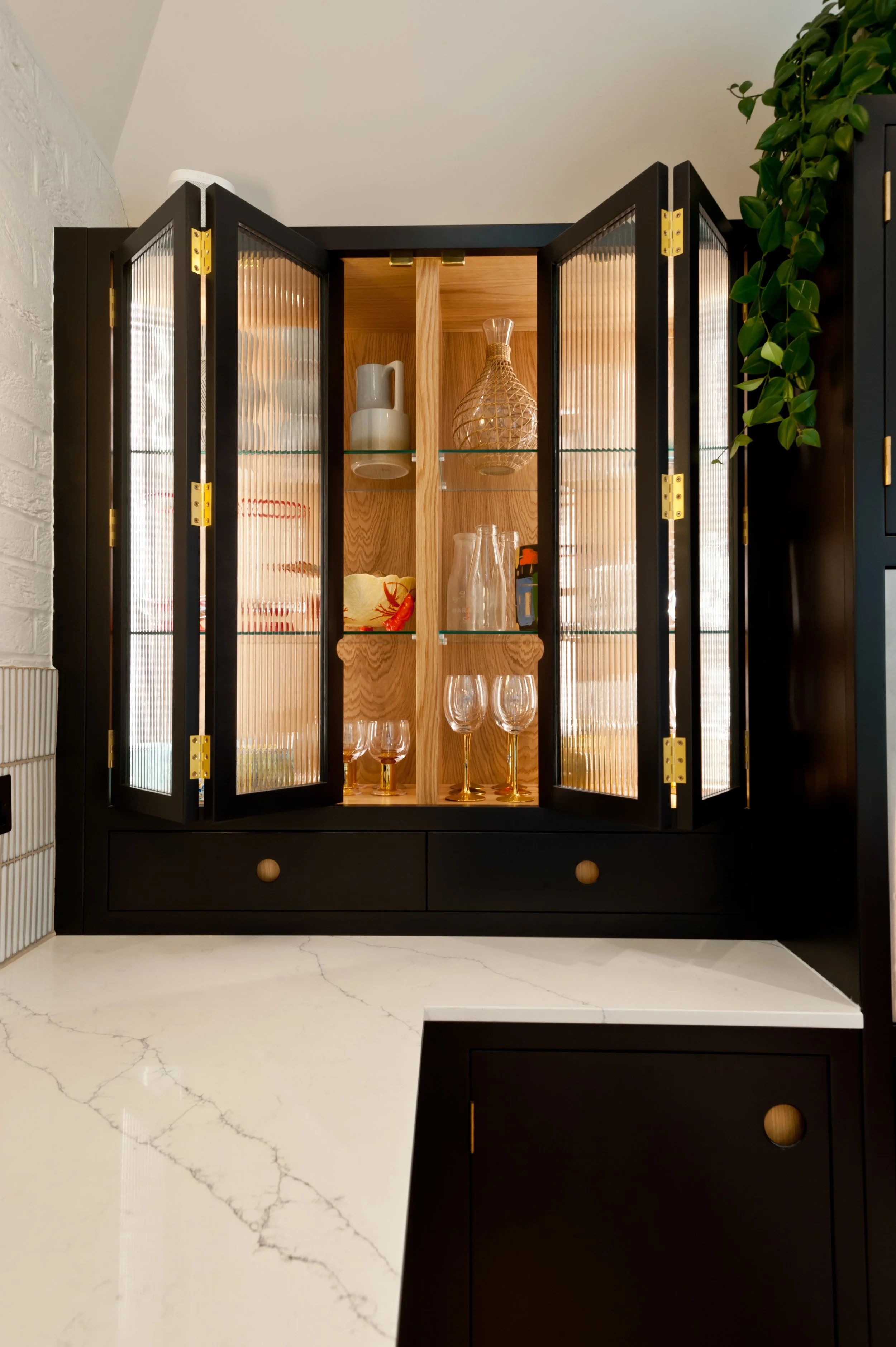 After dark. A bespoke glazed drinks cabinet with fluted glass, warm lighting and beautifully considered storage.