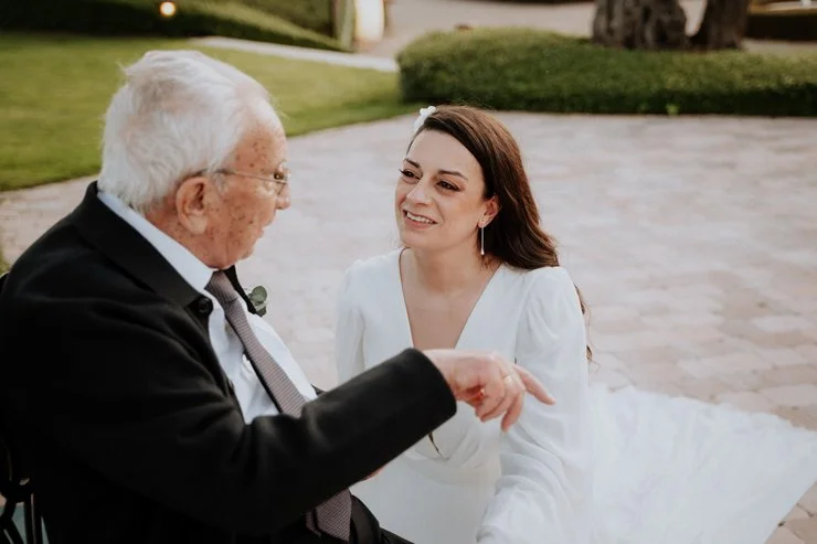 fotografía novia y anciano en una conversación en un patio exterior en boda ,Madrid, Raquel Botas.