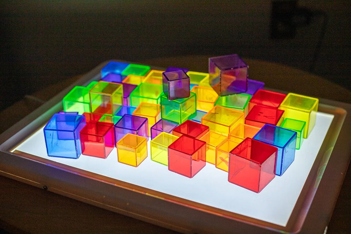 Colorful translucent plastic cubes on a glowing tablet surface.