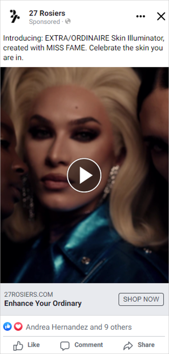 Close-up of a woman with blonde hair, makeup, and earrings, wearing a shiny blue jacket, flanked by two partially visible people.