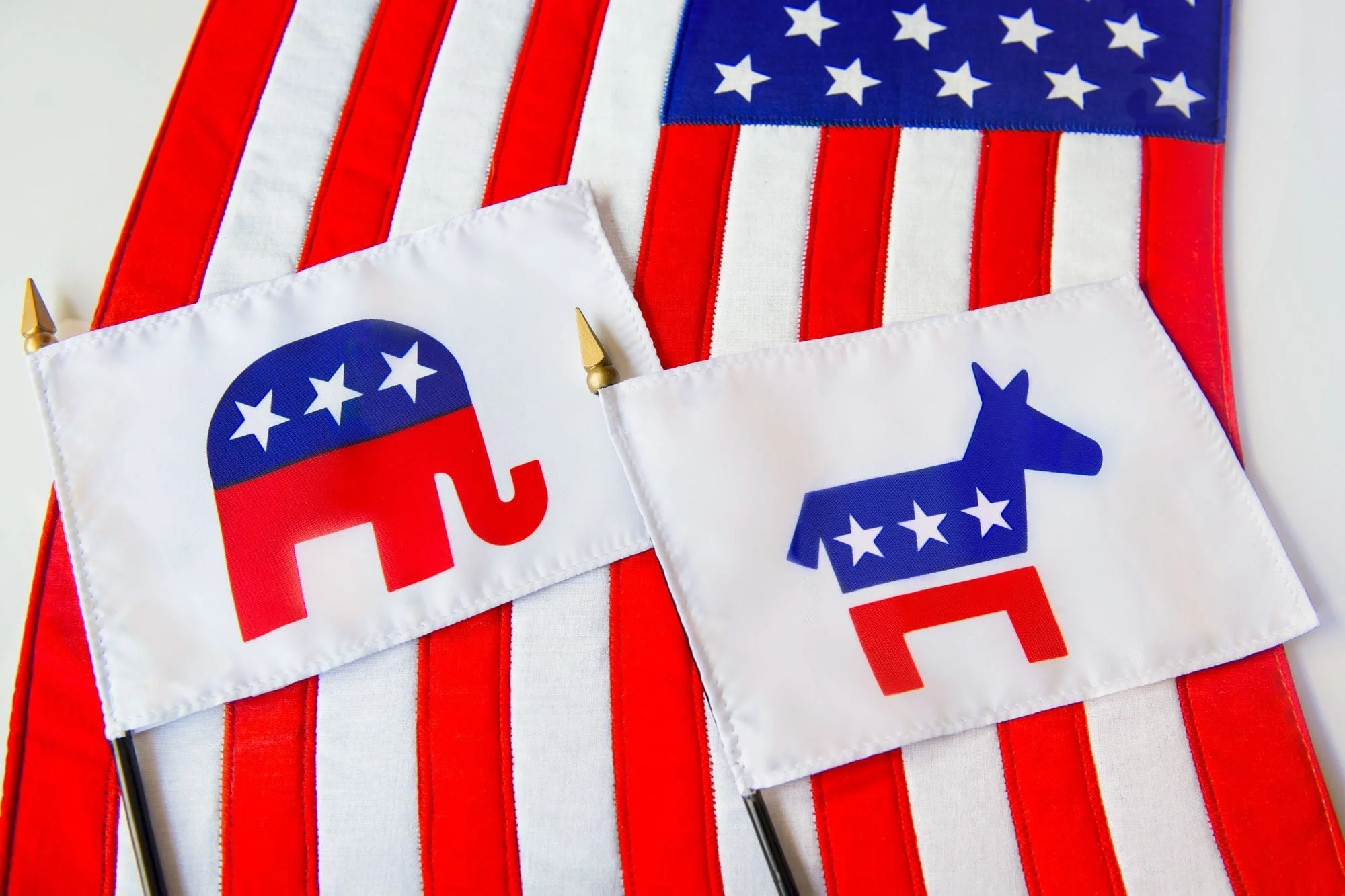 Republican-Elephant-and-Democratic-Donkey-political-party-symbols-on-two-small-flags-laying-on-the-American-Flag-GettyImages-1167212213_KSedit_FT.jpg