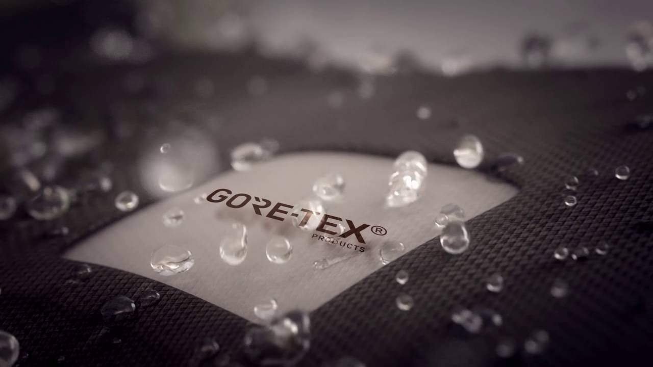 Close-up of a GORE-TEX fabric label on a water-resistant jacket with water droplets on the surface.
