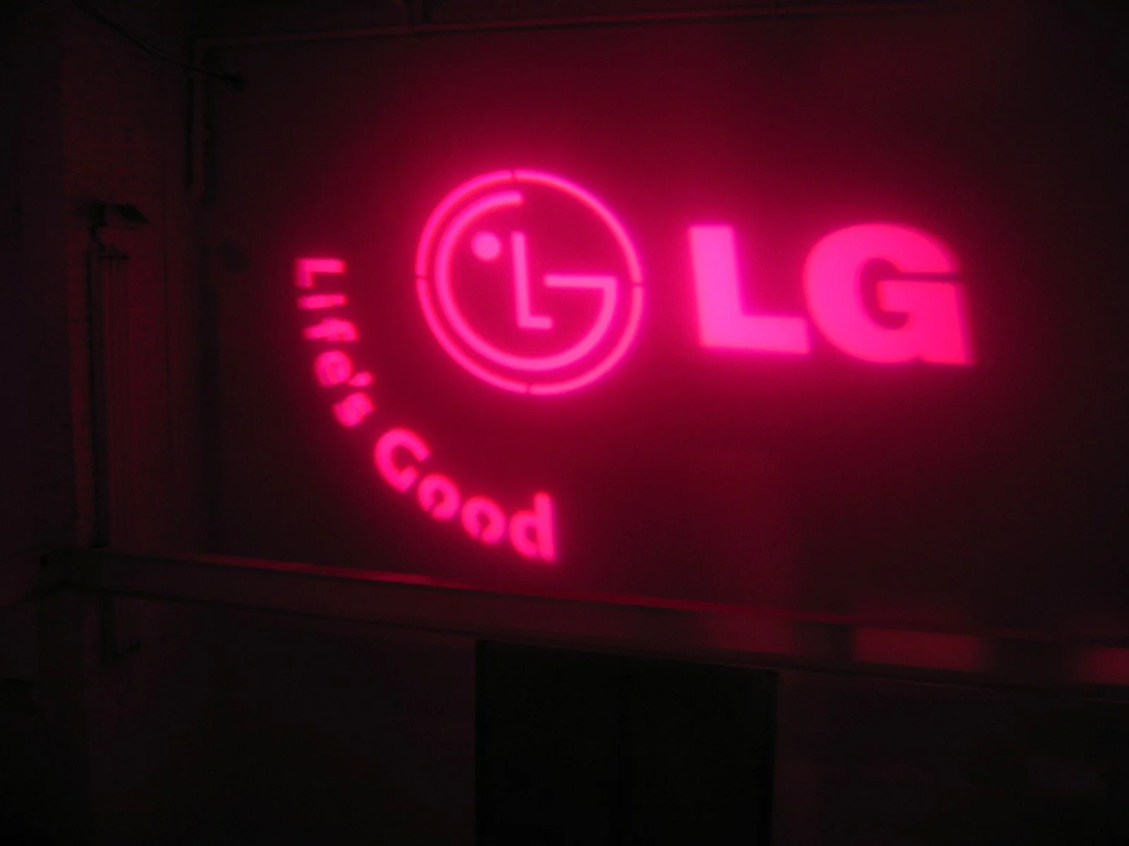 Pink neon sign with the LG logo and the words 'Very Good' in a circular arrangement.