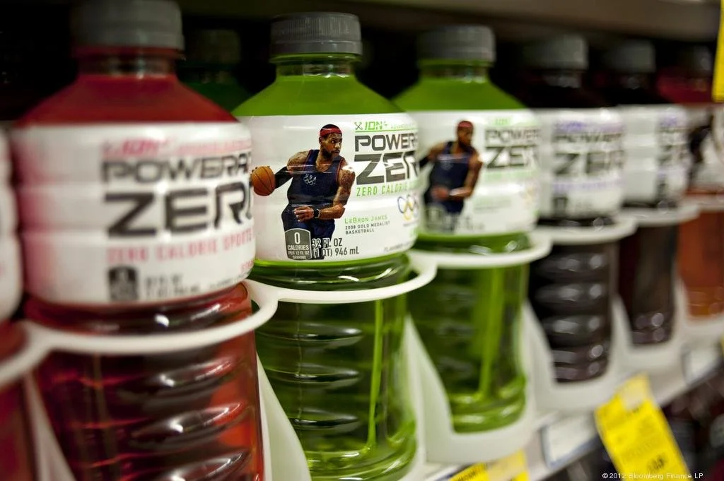 Shelf displaying bottles of Power Zero zero-calorie sports drink with LeBron James on the label, in various colors.