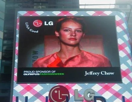 Digital screen displaying a woman in an orange-red dress, with logos and text including 'LG', 'Live. Good.', 'Proud Sponsor of Olympus Fashion Week', and the name 'Jeffrey Chow'.