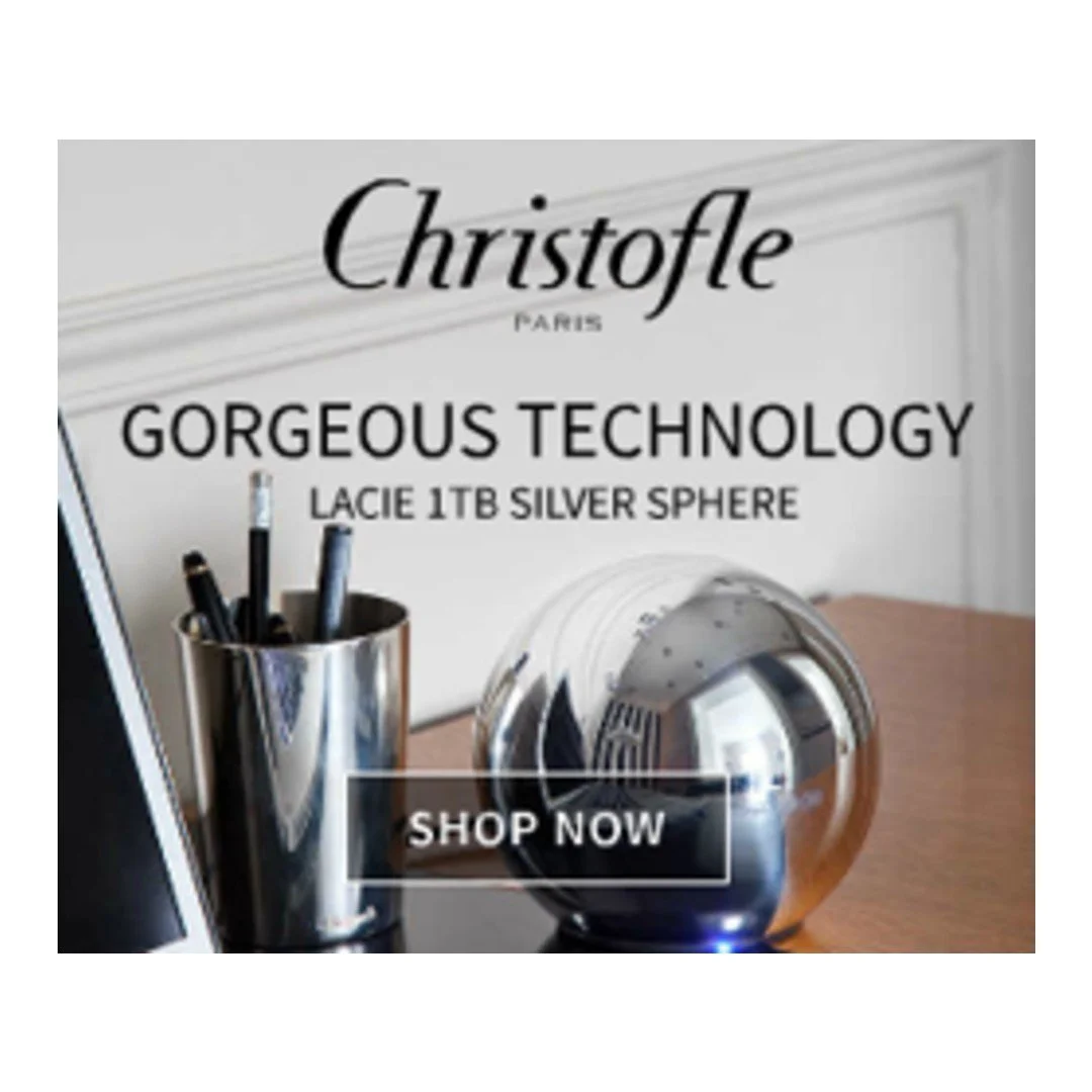 An advertisement for Christofle's Silver Sphere object, featuring a silver sphere, a pen holder with pens, and a tablet, with a "Shop Now" button.