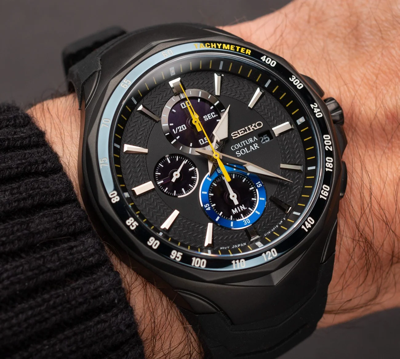 Black Seiko Coutura Solar chronograph watch on a person's wrist with multiple subdials and a tachymeter scale.