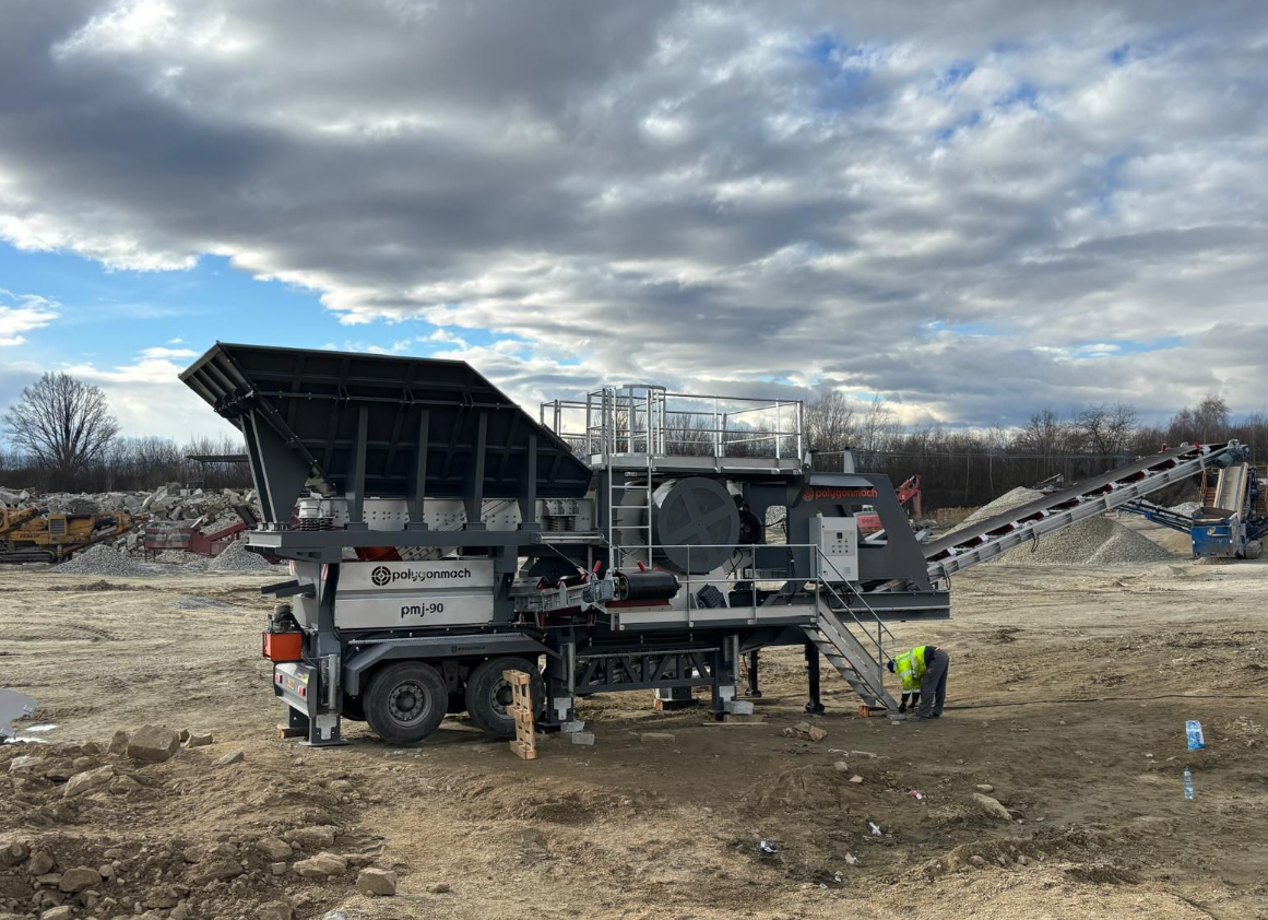 Portable jaw crusher with heavy duty vibrating grizzly feeder and under jaw conveyor with built in tramp protection.