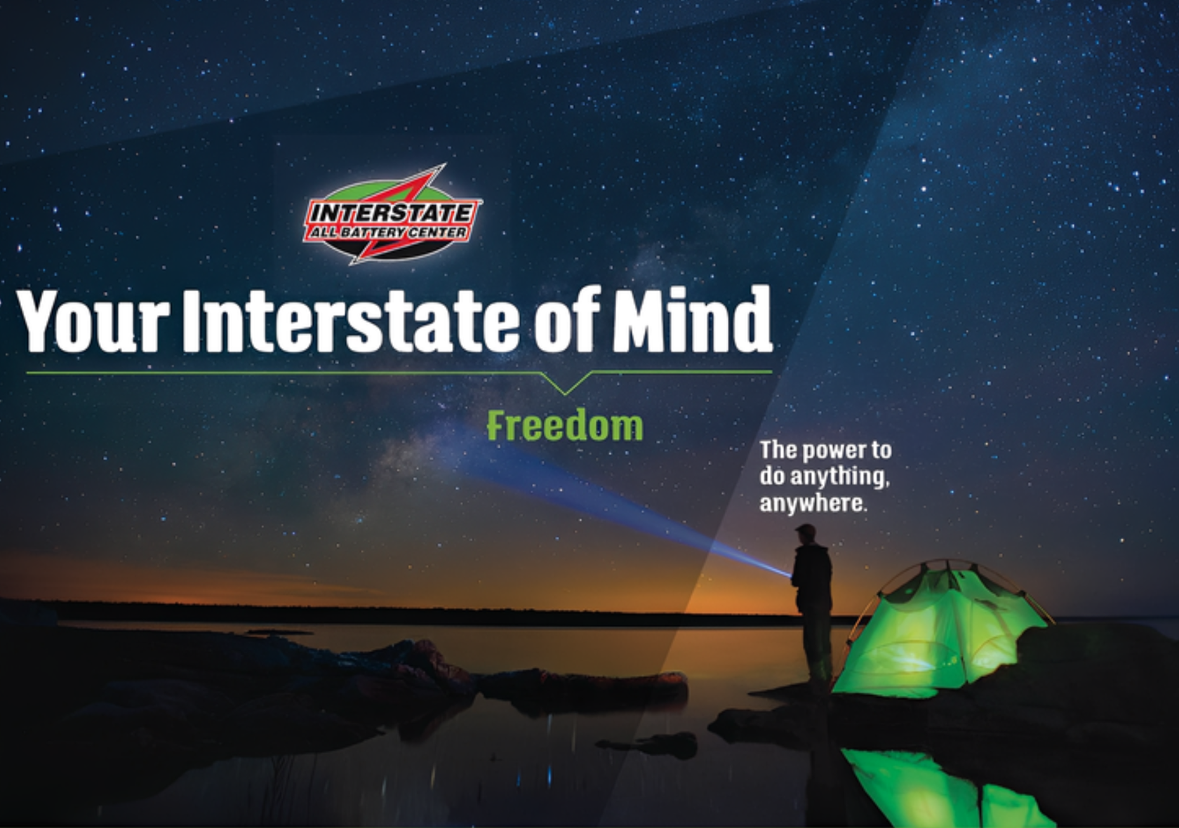 Nighttime scene with a person shining a flashlight into the starry sky near a green tent by the water's edge, promoting Interstate All Battery Center and the theme 'Your Interstate of Mind' with emphasis on 'Freedom' and 'The power to do anything, anywhere.'