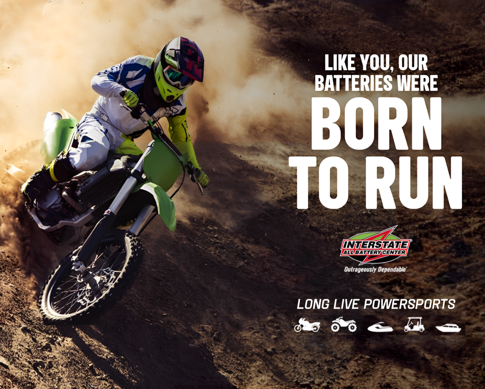 A motocross rider in gear riding a green dirt bike on a rugged dirt trail with dust clouds behind them. Text overlay says, "Like you, our batteries were born to run" and features the Interstate All Battery Center logo, with smaller icons of other powersport vehicles and the words "Long Live Powersports."