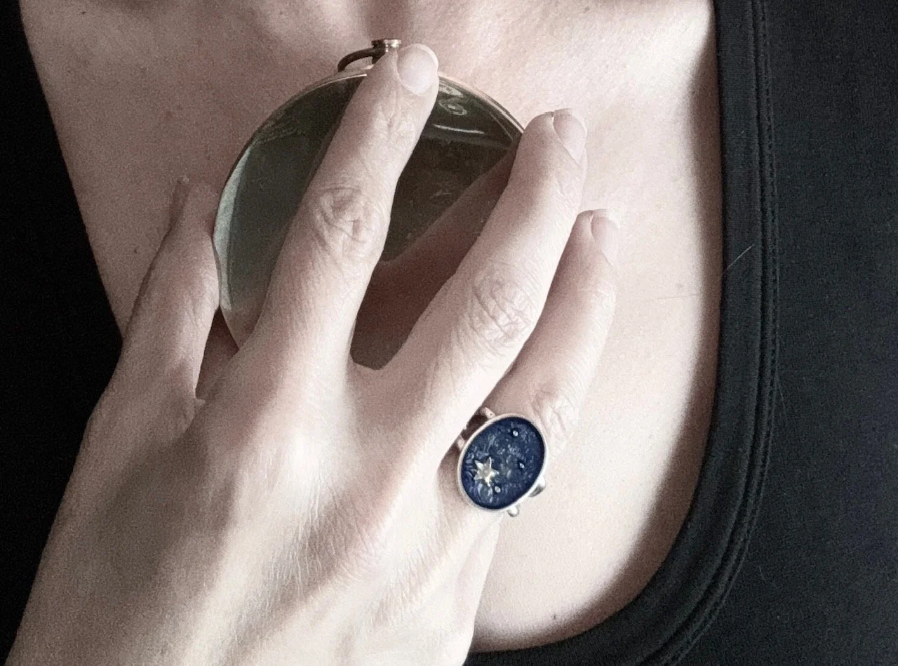 A beautiful woman holding a closed compass on her chest