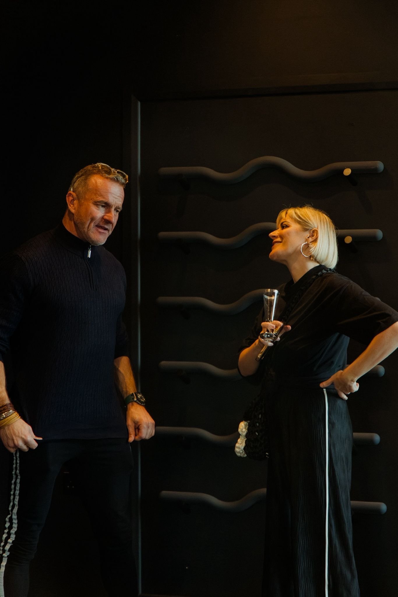 A man and a woman having a chat at the grand opening of Vitalis Studios.