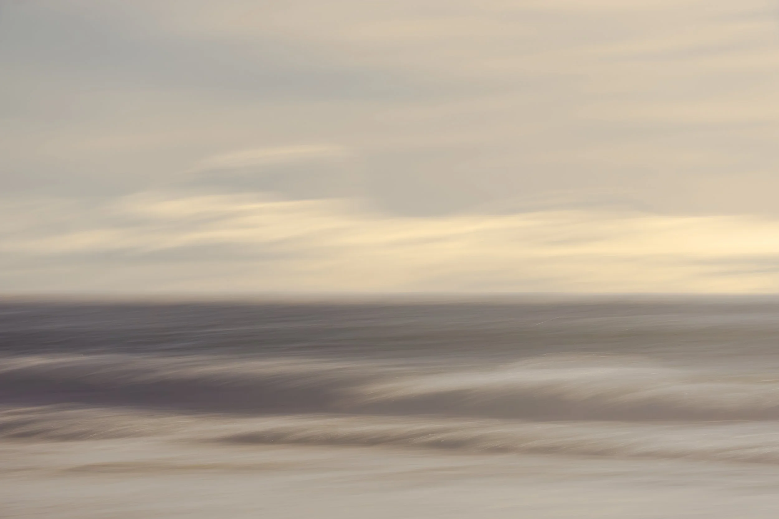 Minimal abstract seascape with soft motion blur, blending clouded sky and ocean into horizontal bands of warm beige and muted gray tones.