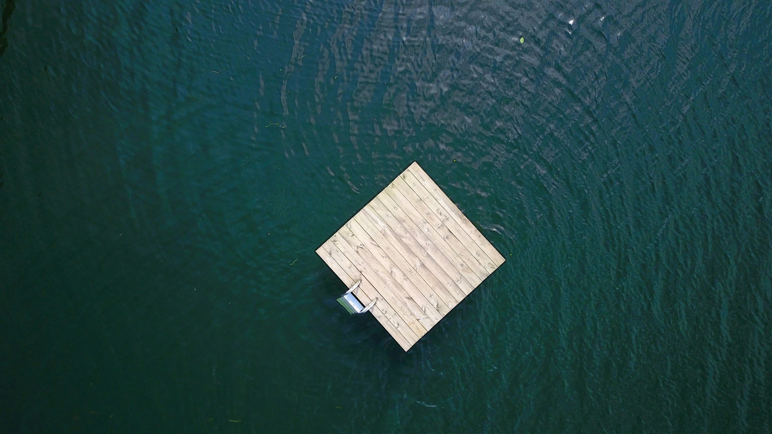 Aerial view of a small raft floating on calm open water