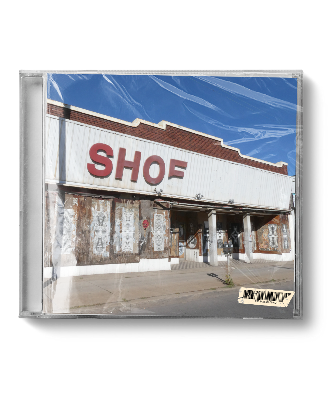 Old storefront with a red sign reading 'SHO' and a partially obscured 'ES' next to it, under a bright blue sky with some clouds.