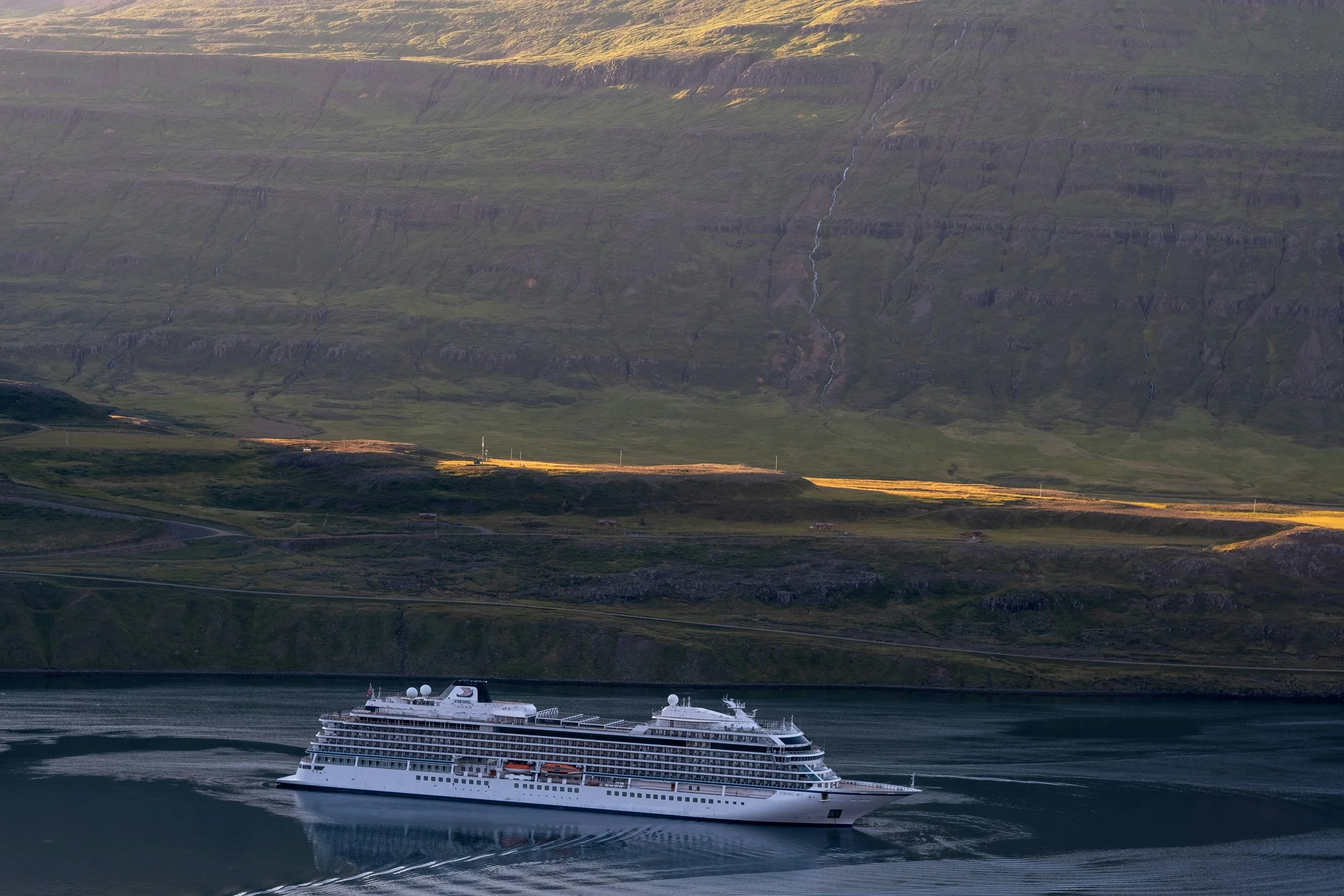 Luxury vehicle driving along Iceland’s scenic coastline at sunset, representing VIP transportation and personalized concierge services for high-end travelers.