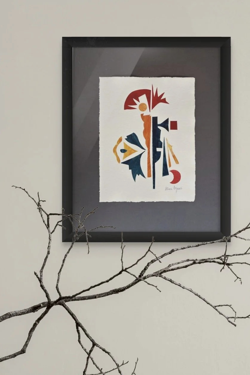 Colorful abstract artwork framed on a wall with a bare tree branch in front.