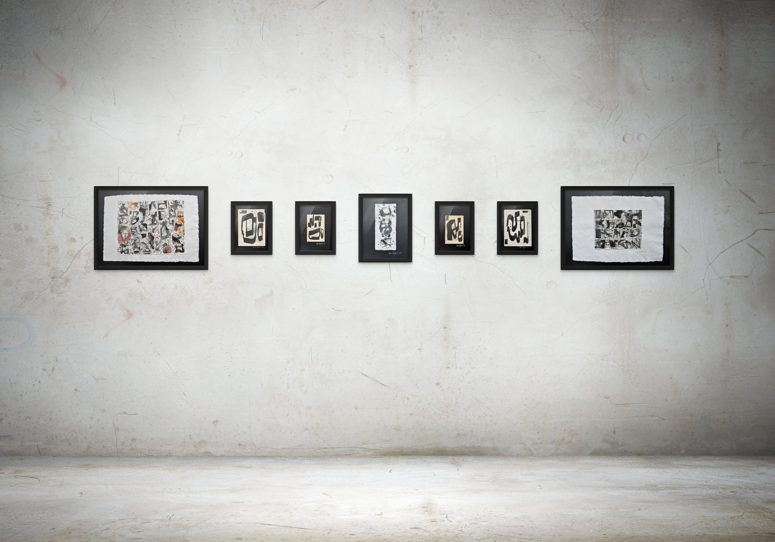 Gallery wall with seven framed abstract black and white artworks on a textured, off-white wall.