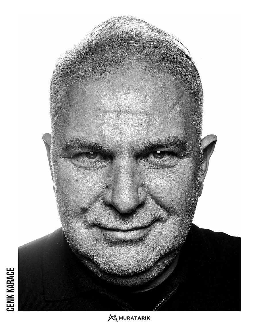 Black and white close-up portrait of a middle-aged man with short, hair, smiling slightly.