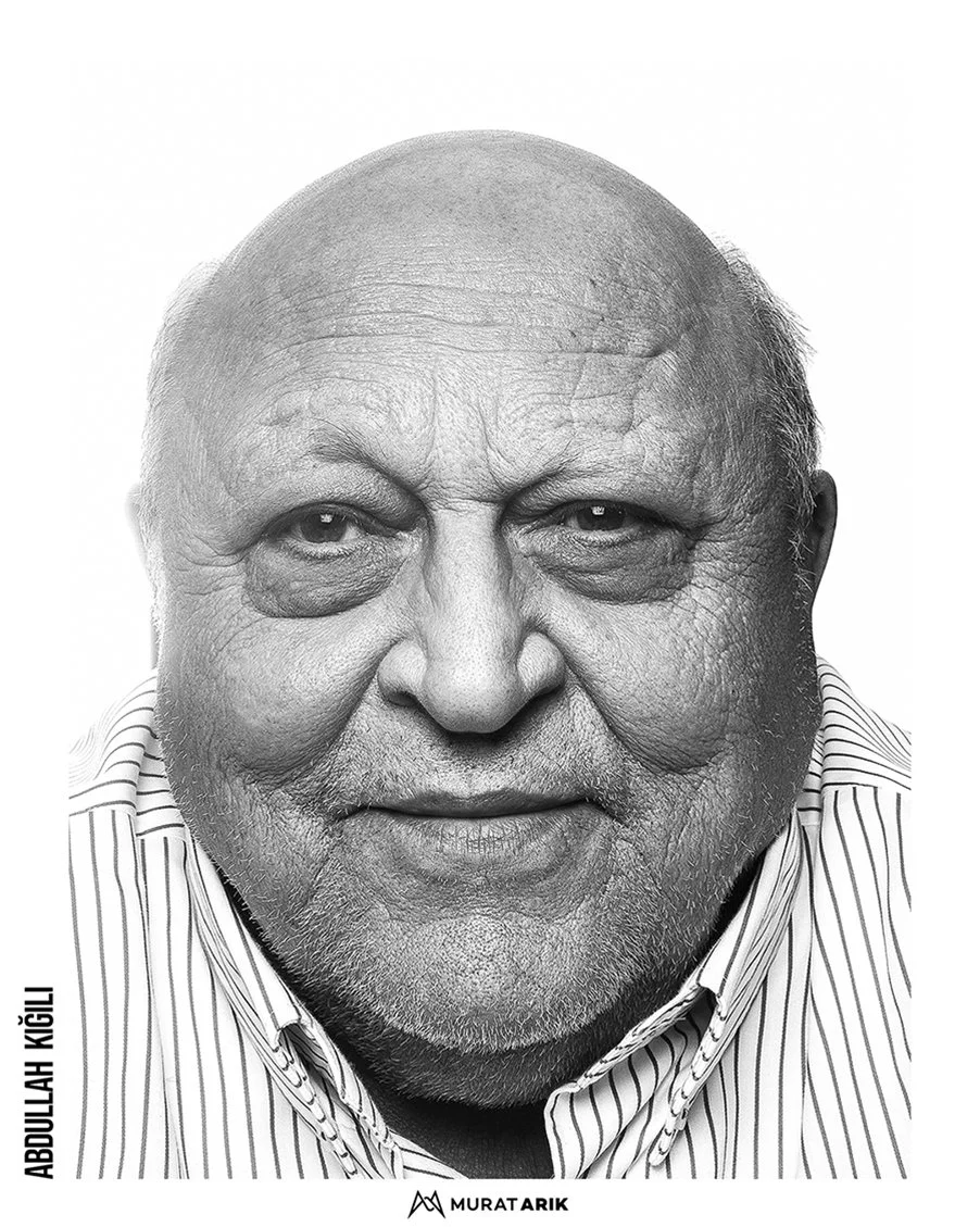 Close-up black and white portrait of an elderly man wearing a striped shirt, smiling gently, with the name Abdulllah GÜGÜL and logo at the bottom.