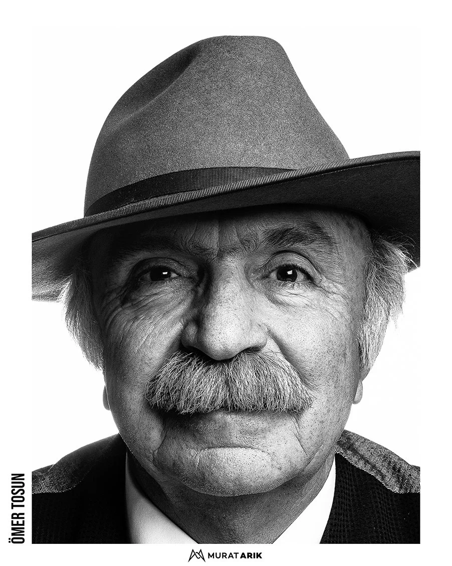 Black and white portrait of an elderly man with a large mustache, wearing a wide-brimmed hat and a suit jacket.